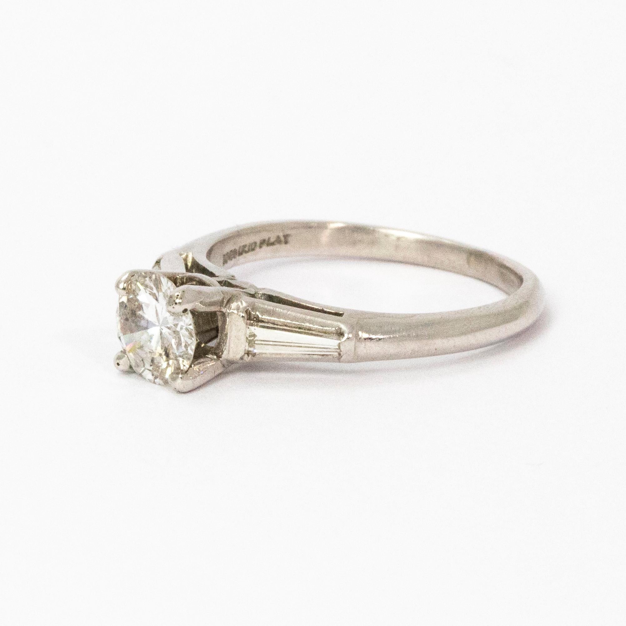 Stunning 1930s Art Deco diamond solitaire. Centre brilliant cut diamond weighing 1.35 carats, F colour and SI-2 clarity, and features tapered baguette diamond shoulders set in 18 karat white gold.

Ring Size: M or 6 1/2