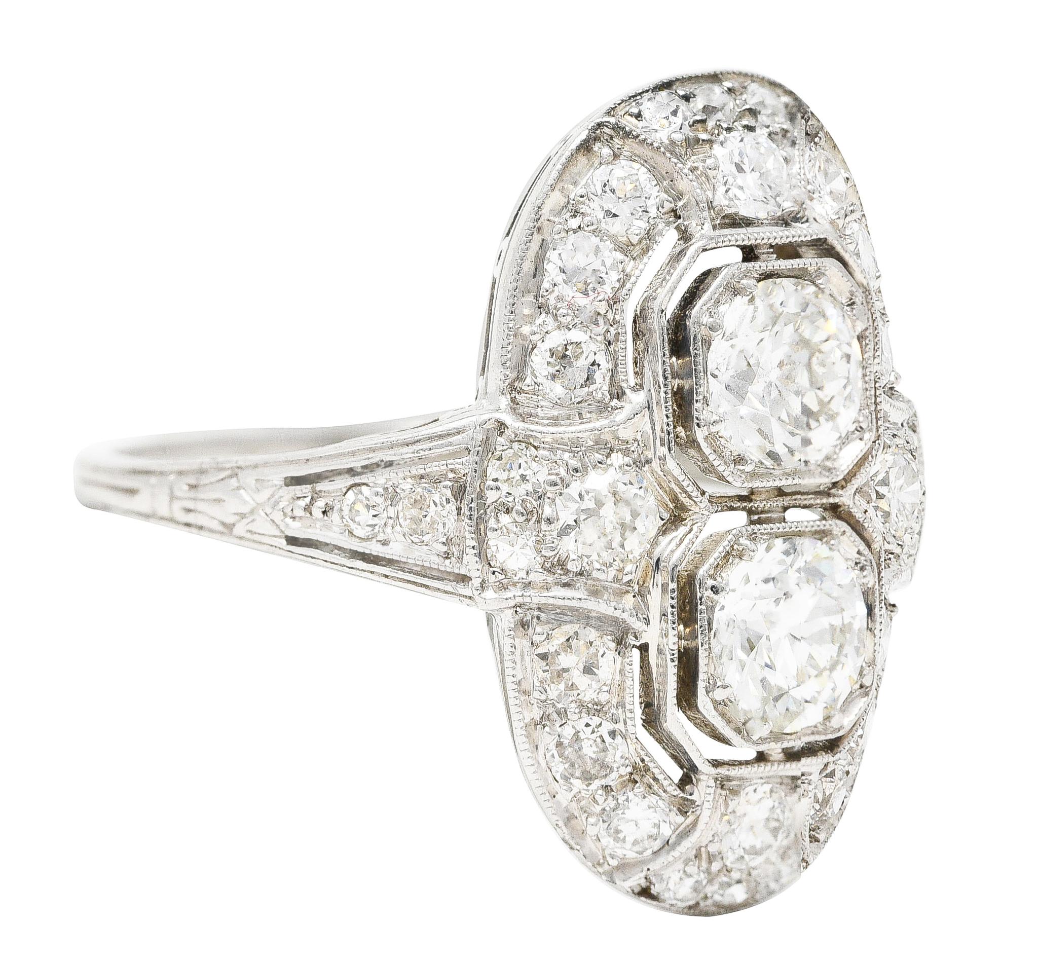 Designed as an elongated oval form centering two old European cut diamonds. Weighing approximately 0.80 carat total - I color with VS2 clarity. Bead set North to South in two pierced octagonal form heads. Accented by old European cut diamond halo