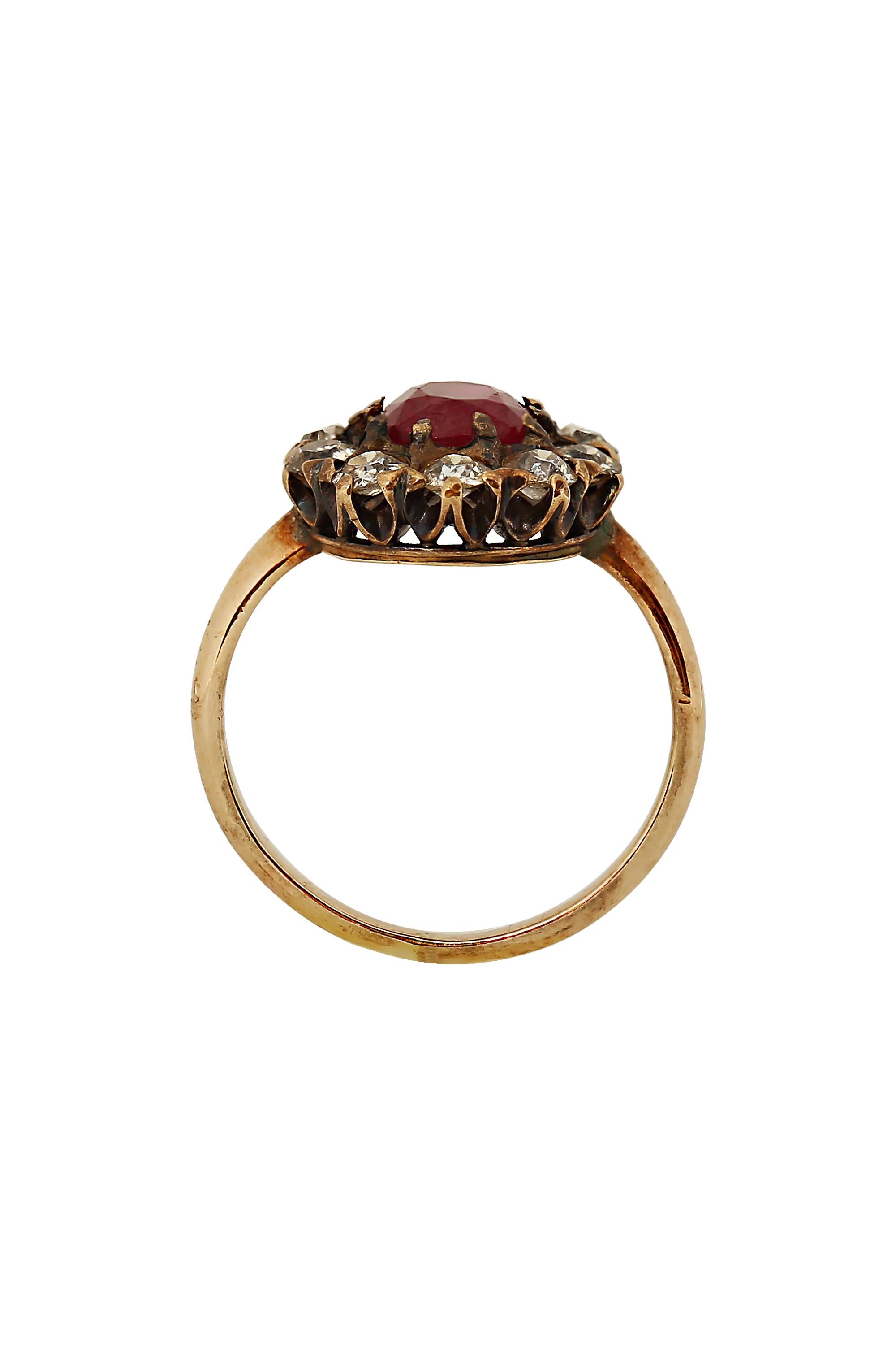A romantic classic, this ring centers a rich red ruby glowing from within a fame of sparkling Old European cut diamonds in a hand fabricated 10 karat yellow gold mounting. Set with ten Old European cut diamonds weighing approximately 1.30 carats and