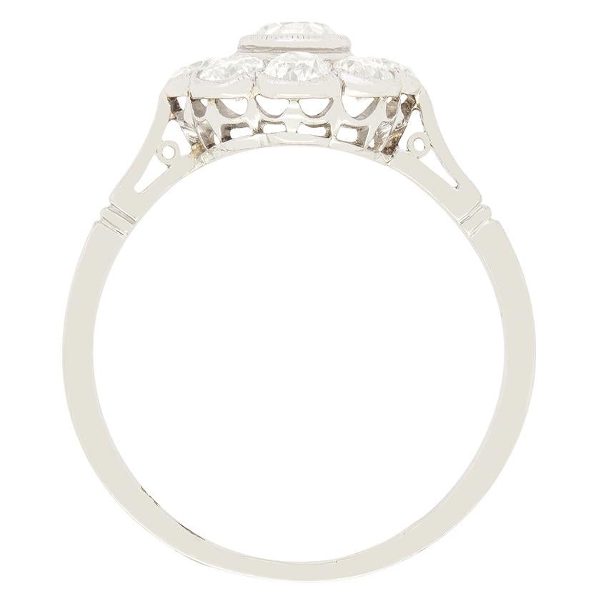 Ein atemberaubendes Beispiel für die Eleganz des Art Déco ist dieser reizvolle Gänseblümchen-Ring, in dessen Zentrum ein Diamant im Altschliff von 0,40 Karat steht, der in Platin gefasst ist. Um ihn herum bilden acht Diamanten im Altschliff von 0,15
