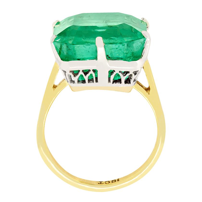 Awe inspiring in its size, a huge Columbian emerald sits proudly in this solitaire ring dating to the Art Deco era. The 16.48 carat emerald cut stone has had moderate oiling helping the vivid green stone look its best. The original hand crafted 