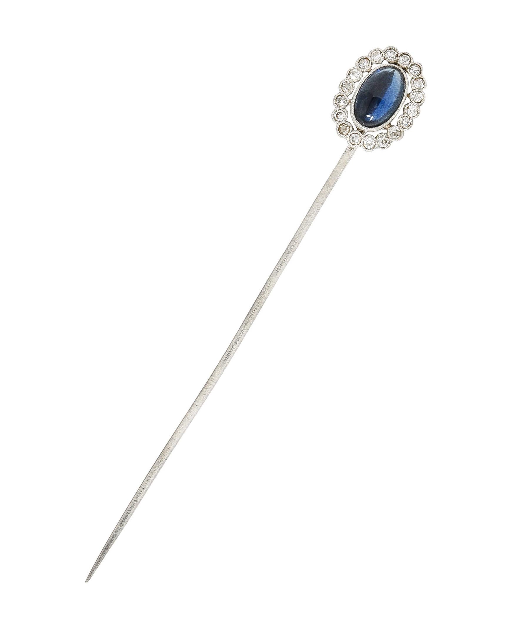 Centering an oval shaped sapphire cabochon weighing approximately 1.29 carats total. Transparent medium to dark blue in color - bezel set with a pierced halo surround. Comprised of old mine cut diamonds weighing approximately 0.36 carat total. Eye