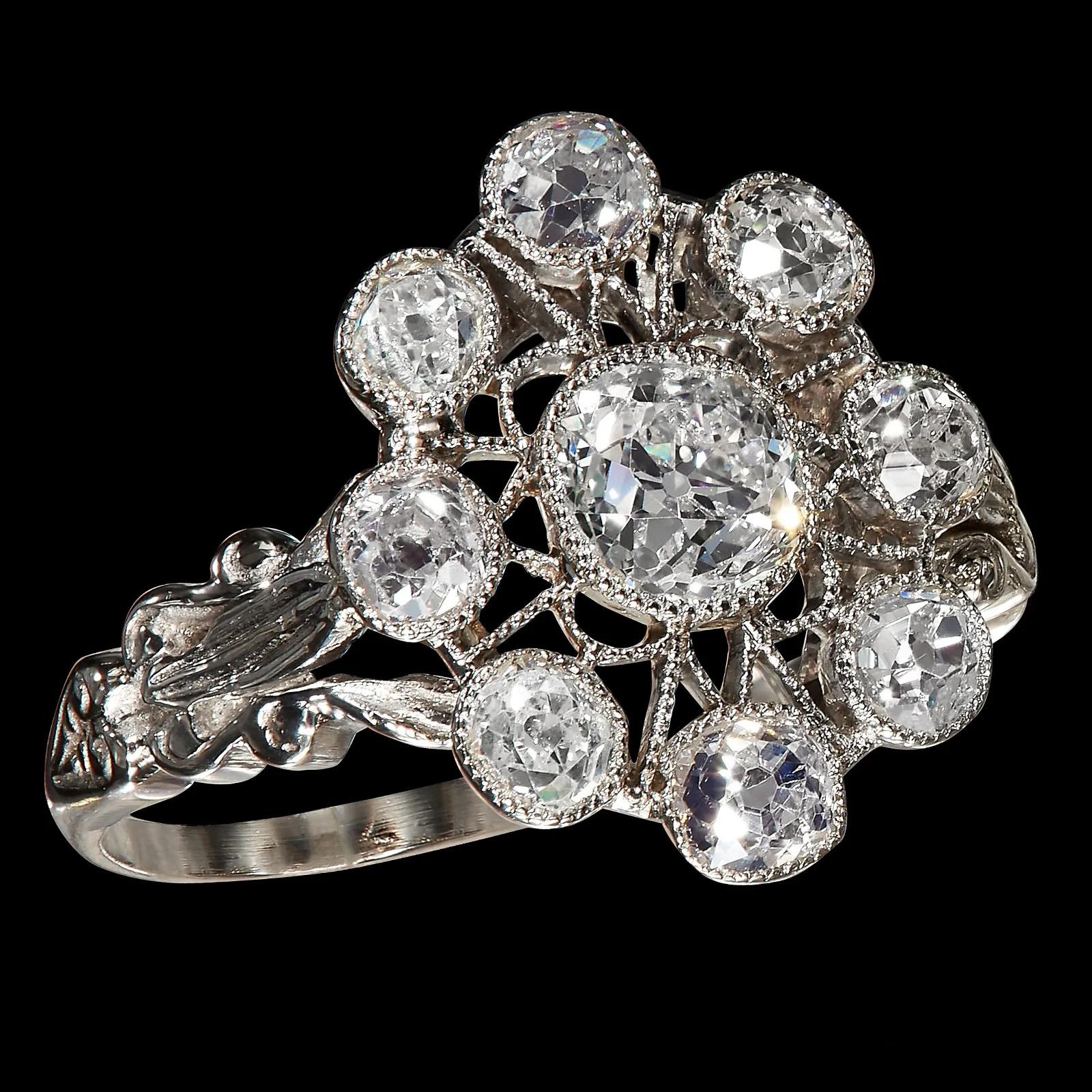 Super Rare and Authentic 1917. This breathtakingly beautiful and shimmering early Art Deco Cluster European-made bright Platinum Ring containing 9 bezel-set OLD EUROPEAN cut Diamonds with a total weight of approximately 1.65cts. 
Before the diamonds