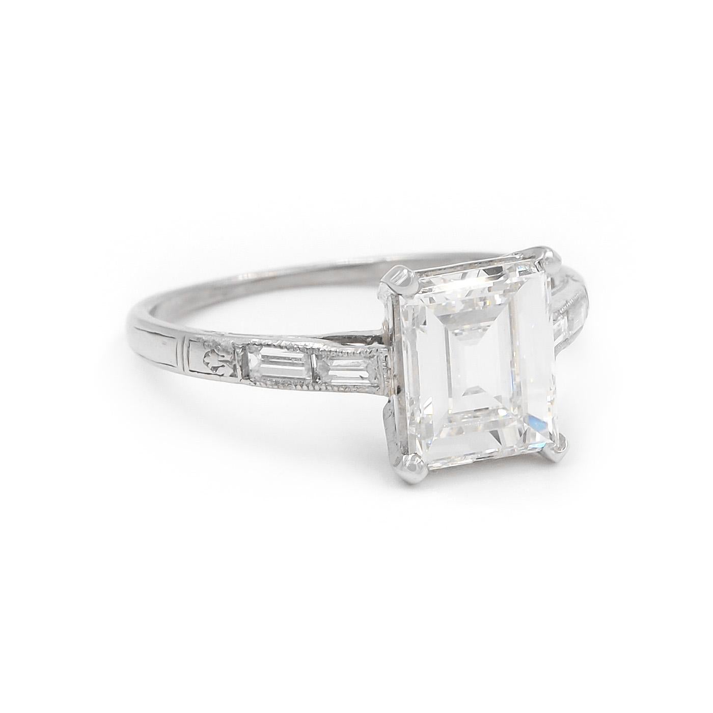 American Art Deco Era 1.67 Carat Step Cut Diamond Engagement Ring composed of platinum. Featuring a 1.67 carat Step Cut diamond, GIA certified H color & VS2 clarity. With an additional 4 Baguette Cut diamonds set into the shoulders weighing