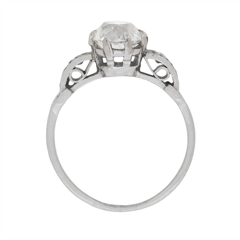 This simply opulent antique diamond solitaire engagement ring centres a sublime 1.68 carat round old cut diamond in its original eight claw mounting between a pair of sparkling diamonds and split shoulders to either side. The stones lining the