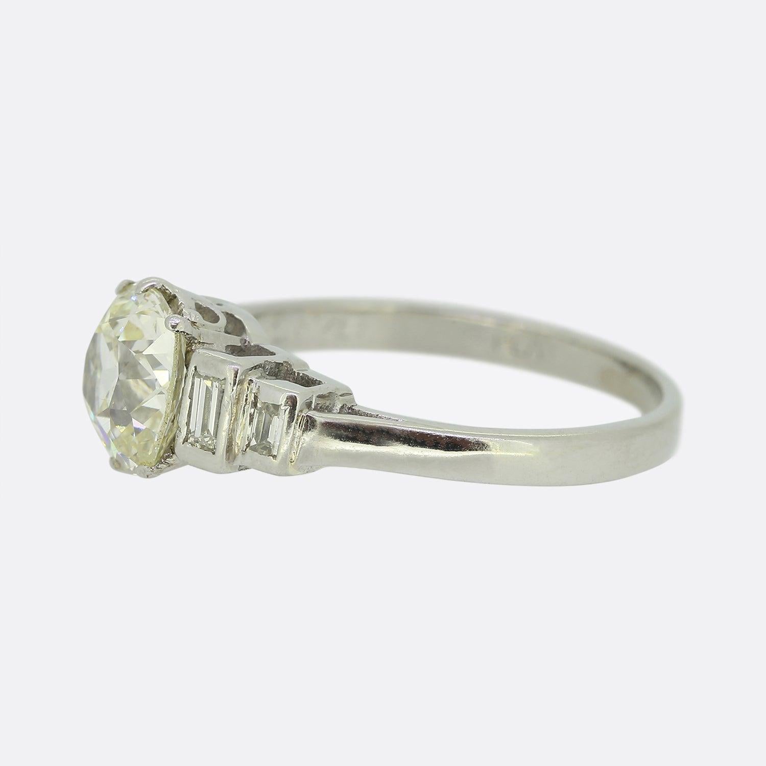 Nous avons ici une charmante bague de fiançailles en diamant, réalisée à une époque où le style Art déco était à son apogée. Un diamant taille coussin de 1,70 carat repose fièrement au centre de la face et est flanqué d'une paire d'épaules étagées,