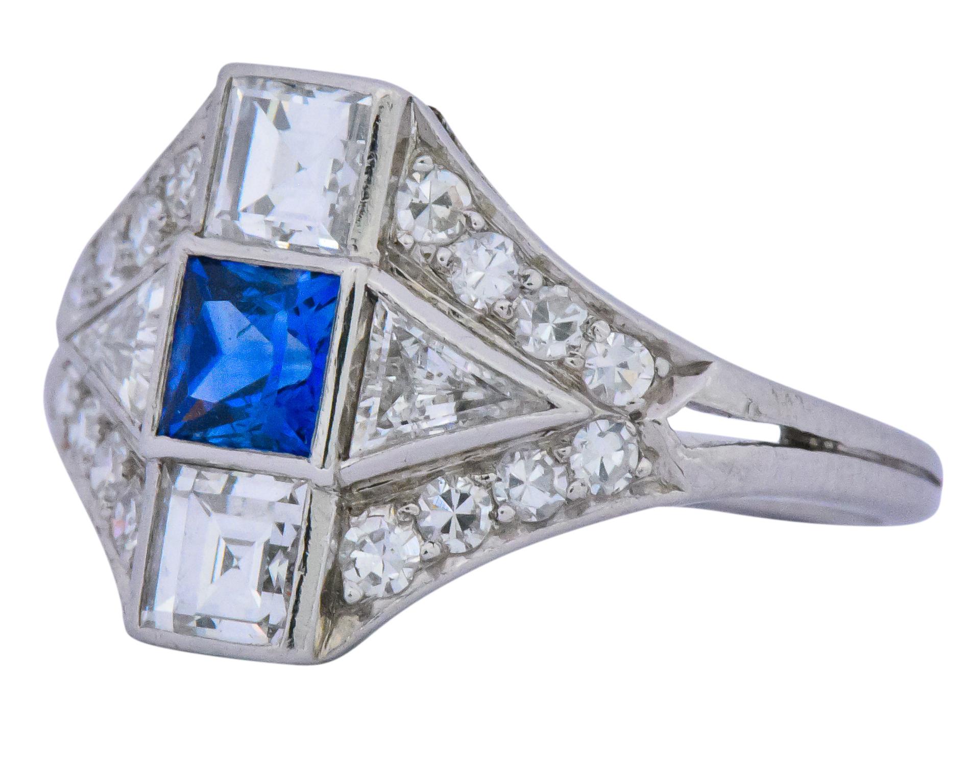  Centering a princess cut sapphire weighing approximately 0.50 carat, bright cornflower blue

Accented by square step, triangular and single cut diamonds, weighing approximately 1.20 carats total, GHI color and VS to SI clarity 

Bold yet balanced