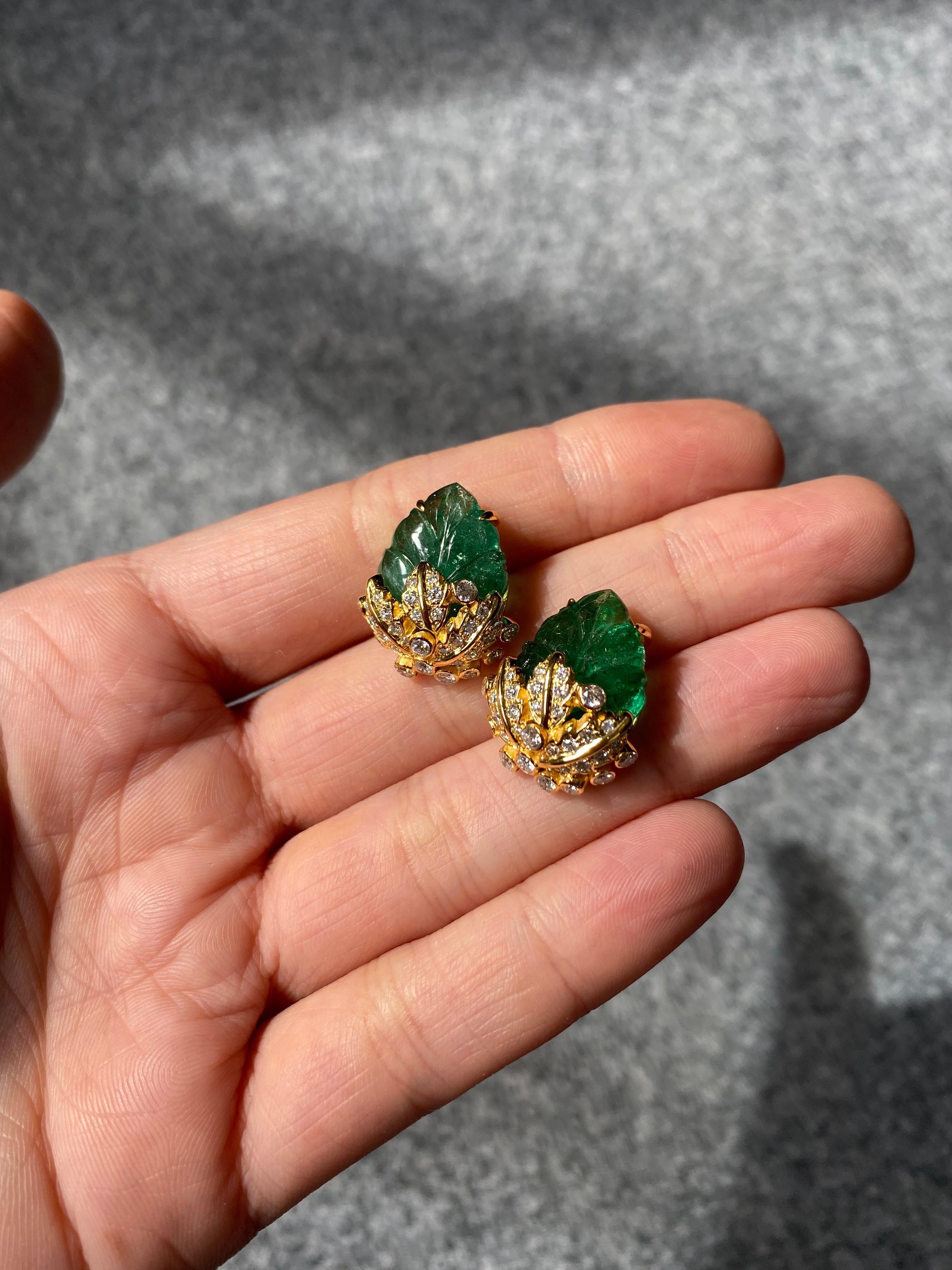 One of a kind, art-deco style, hand-carved 17.01 natural Zambian Emerald and 1.2 carat  White Diamond studs, set in 8 grams of solid 18K Yellow Gold. The design of the earrings are truly unique, and make the yellow gold really enhance the beauty of