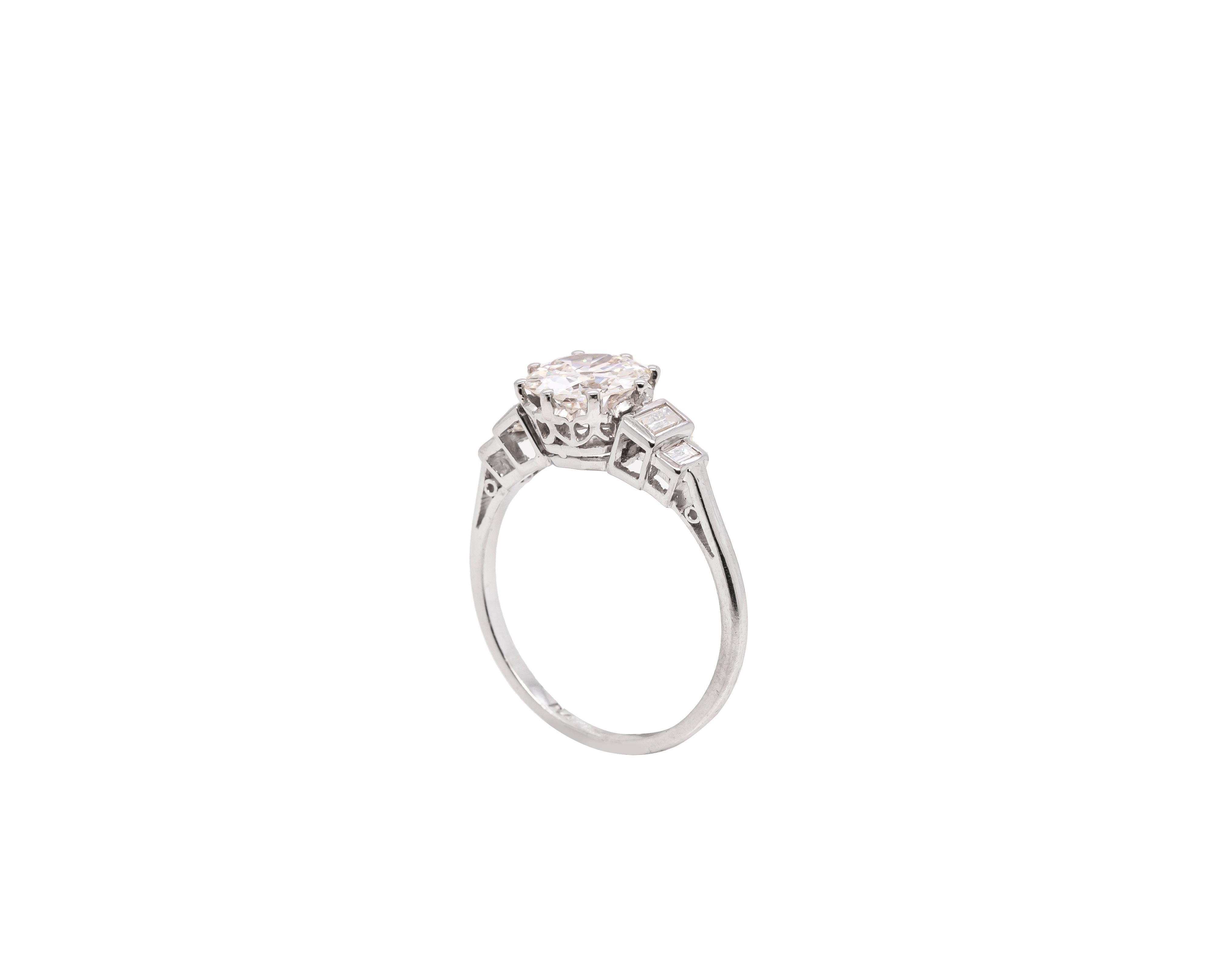 This spectacular antique solitaire engagement ring features a beautiful old European cut diamond weighing 1.72 carat mounted in an eight claw, open back setting. The diamond is perfectly accompanied by two baguette cut diamond steps on either side