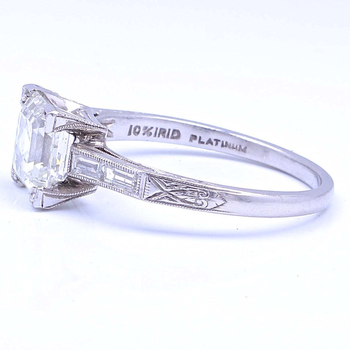 From the Art Deco Era comes this very stylish, elegant diamond representing an engagement ring that will never grow old. The emerald cut diamond weighs 1.77 carats, I,J color, VS1 clarity. Accompanied by 4 baguette cut diamonds weighing 0.22 carats,