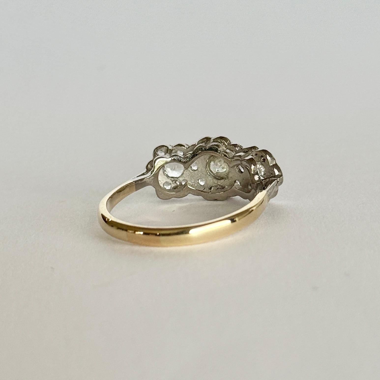 This triple cluster diamond ring, holds three larger diamonds measuring a total of 40pts. The diamonds surrounding them total 60pts and the ring is modelled in 18carat gold and platinum. 

Ring Size: P 1/2 or 8
Triple Cluster Dimensions: