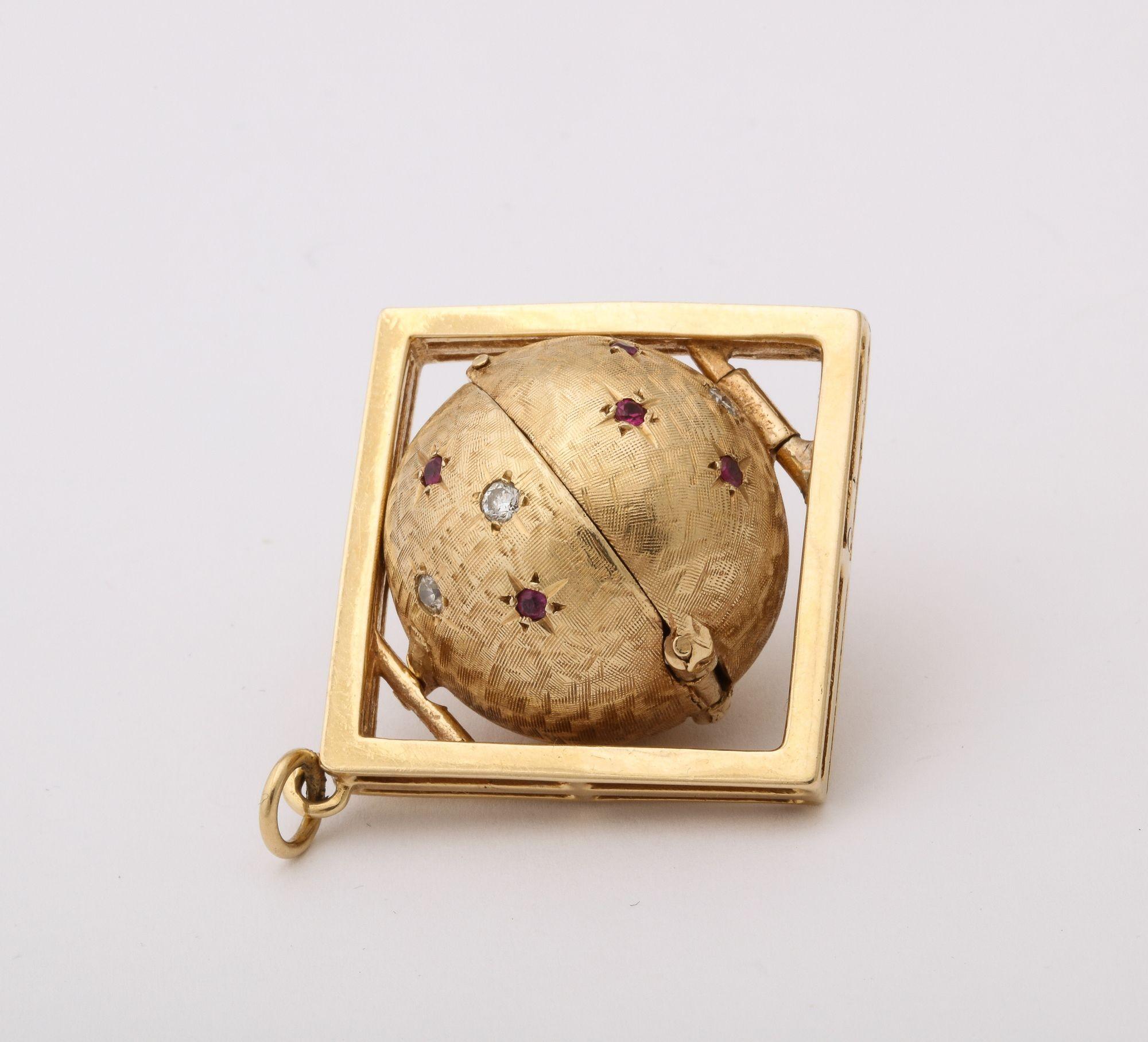 A 14 k Gold Sphere Hinged Locket with Rubies and Diamonds in a gold frame.
The globe opens to reveal 3 chambers for photographs. 1.5” diameter
