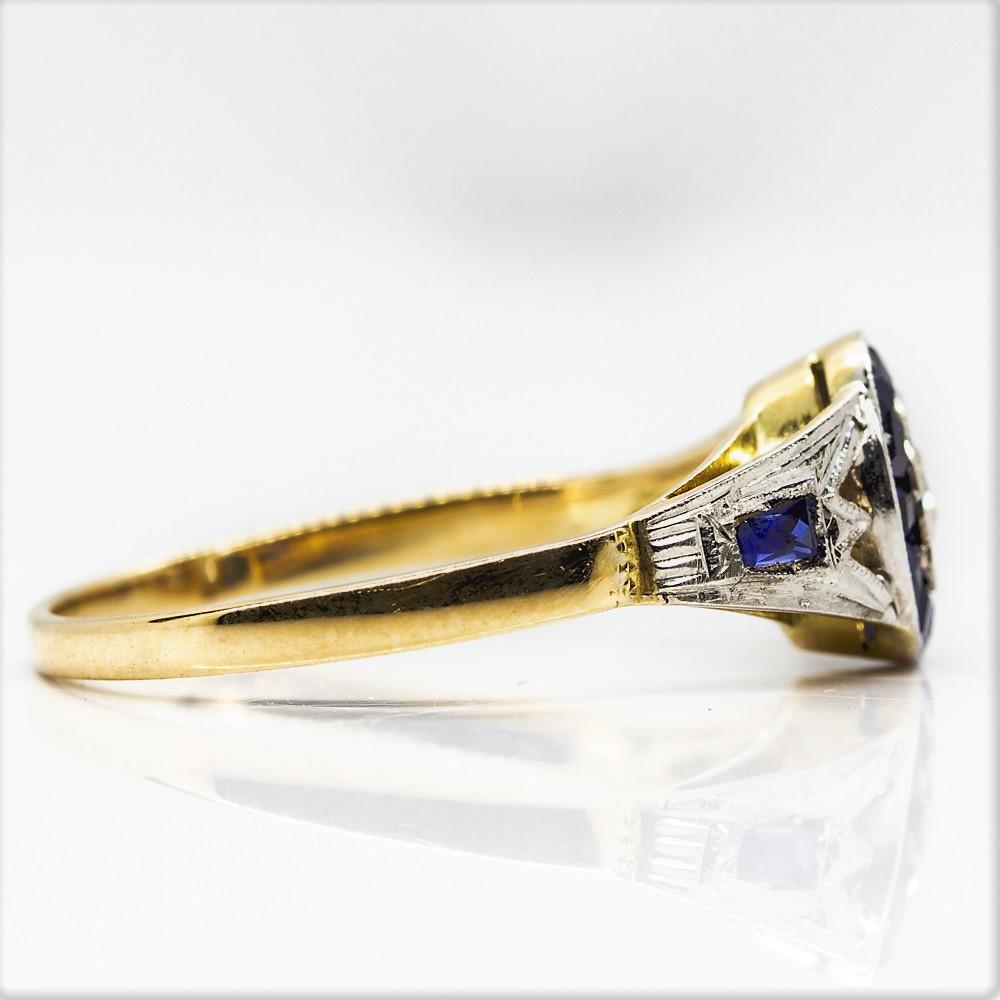 Period: Art Deco (1920-1935)
Composition: 18k Gold and Platinum 
Stones:
•	1 old mine cut diamond I-SI2 0.20ctw
•	12 natural sapphires 0.40ctw
Ring size: 7 ¾ 
Ring face:  16mm by 9mm
Rise above finger: 4mm.¬
Total weight:  2.1grams –