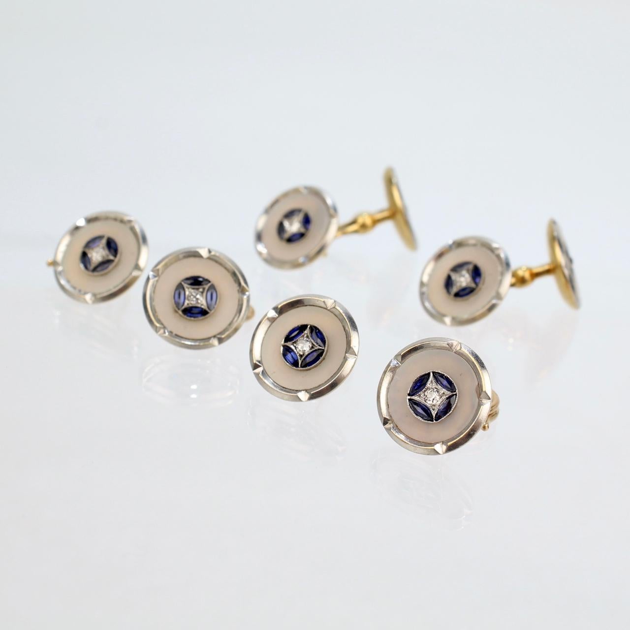 A very fine Art Deco Style cufflink and button set.

Comprised of 4 shirt buttons and a pair of cufflinks.

In platinum-topped 18k gold and set with diamonds, sapphires, and mother of pearl.

Marked to the reverse: 750 for gold fineness and with a