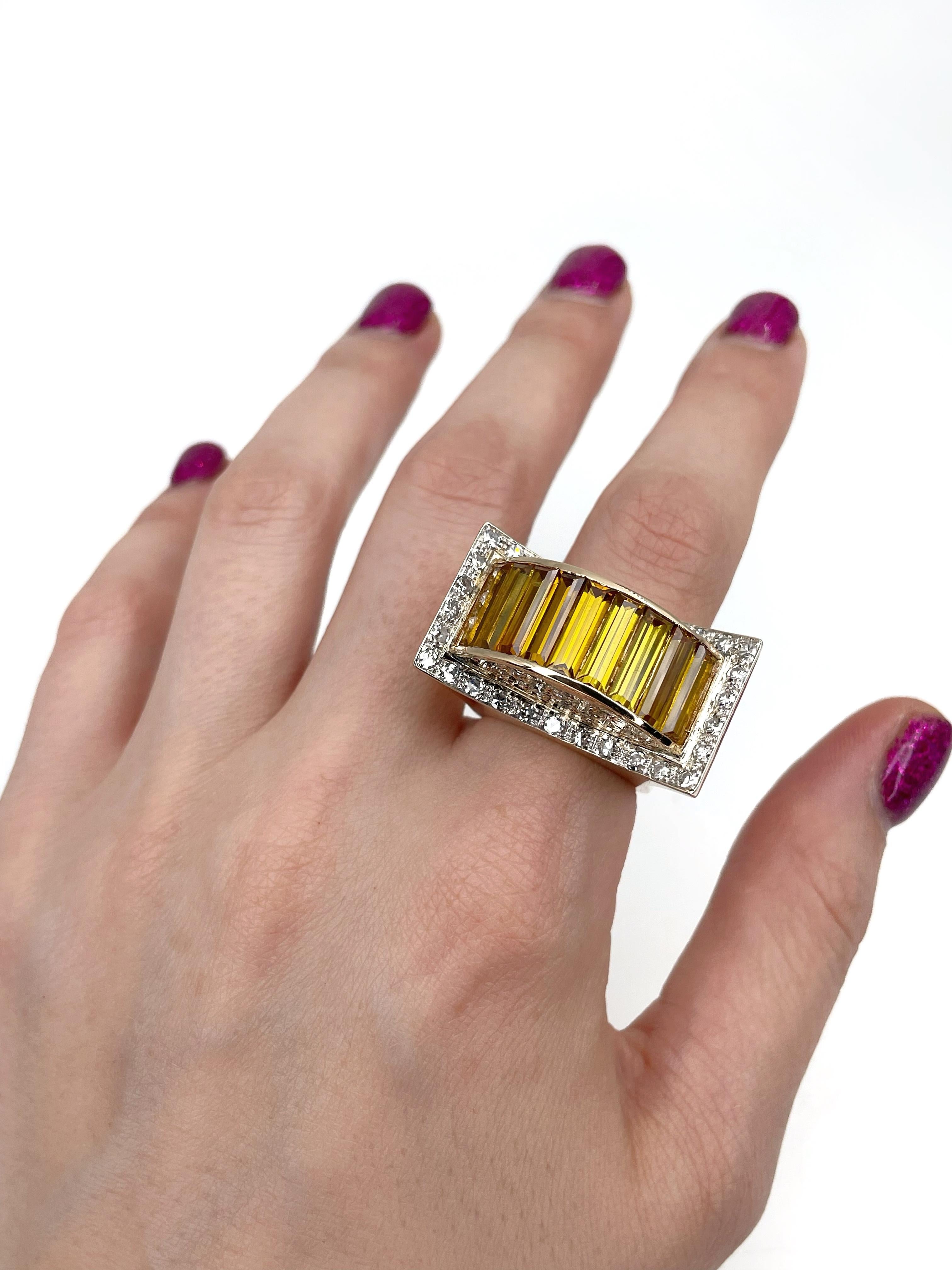 This is an adorable Art Deco cocktail ring crafted in 18K yellow gold. The piece features 9 rectangular step cut synthetic yellow sapphires (TW 6.00ct). There are 44 round cut diamonds: 1.40ct, RW-W, VS-SI. It is adorned with stars motif at the