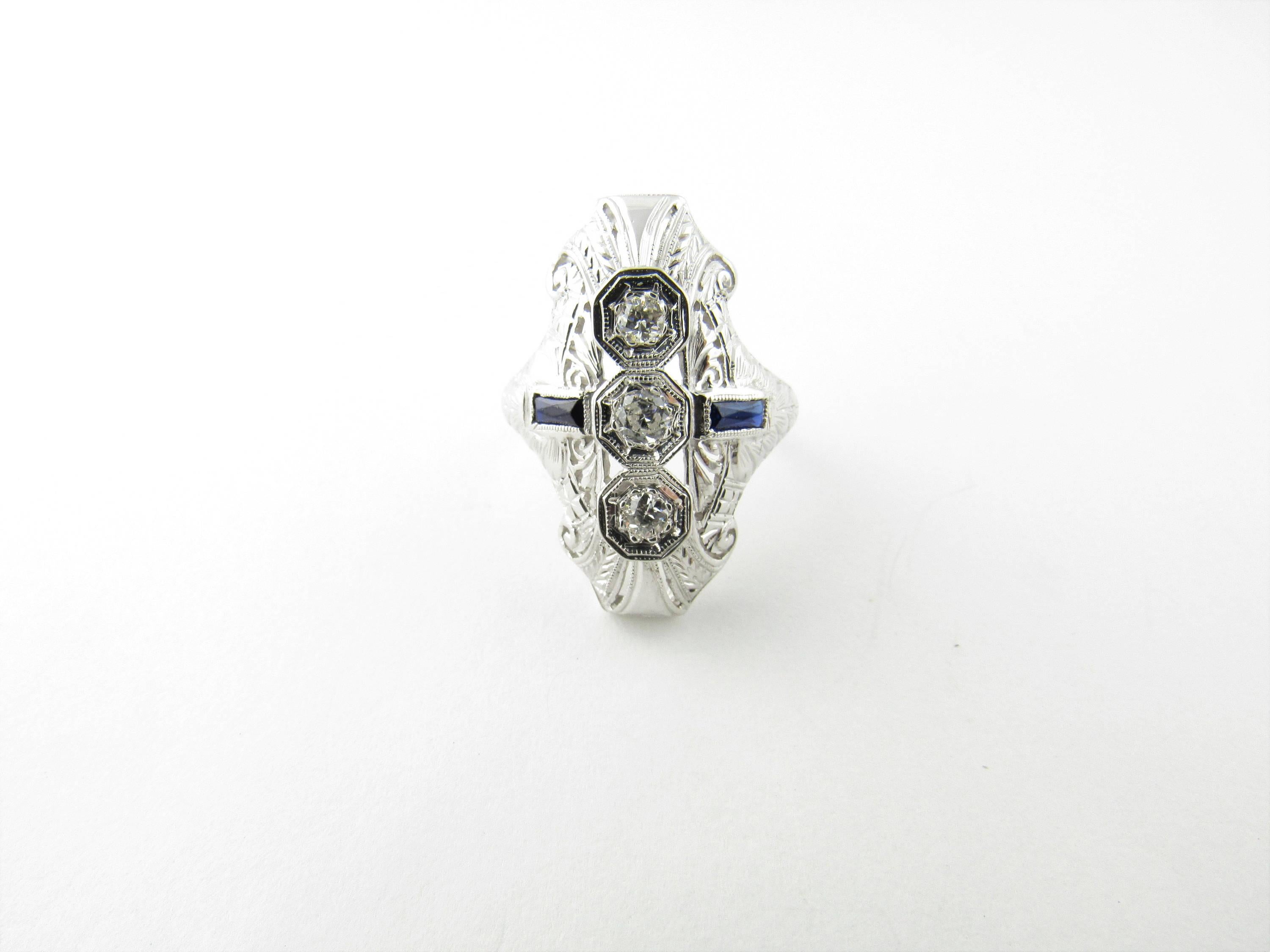Vintage Art Deco 18K White Gold Diamond and Sapphire Ring Size 4.25 Front of ring is 24 mm in length and 14 mm across Back of band is 1.5 mm wide Ring contains 3 diamonds each about .25 carats for a total of .75 carats VS quality diamonds 2 blue