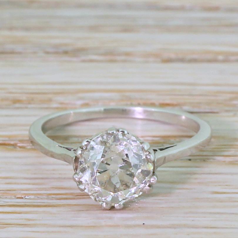 A divine old cut engagement ring. The diamond in the centre, weighing in at a known 1.82 carat, is full of fire and sparkle. The stone is secured by six double-claws in coronet collet, leading to a slim and tapering shank. A classic.

Accompanied by