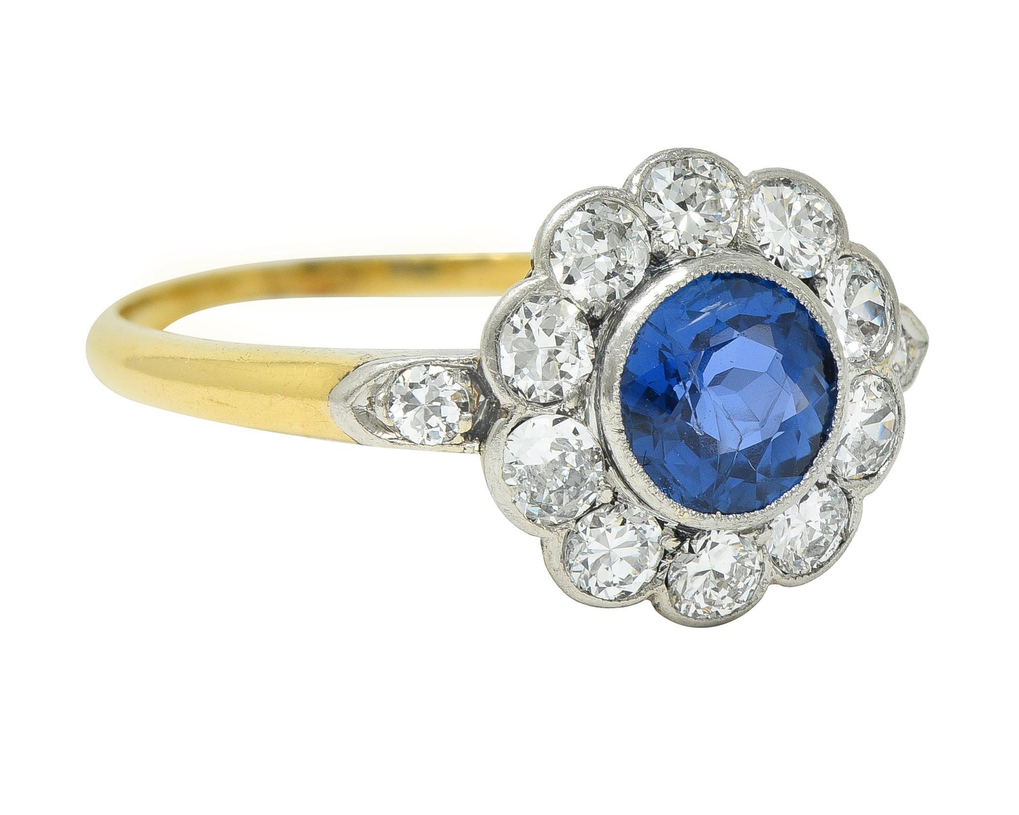 Centering a round cut sapphire weighing 1.00 carats - transparent medium blue in color 
Natural Burmese in origin and displaying no indications of heat treatment
Bezel set in platinum-topped head with milgrain halo surround and shoulders
Bead and