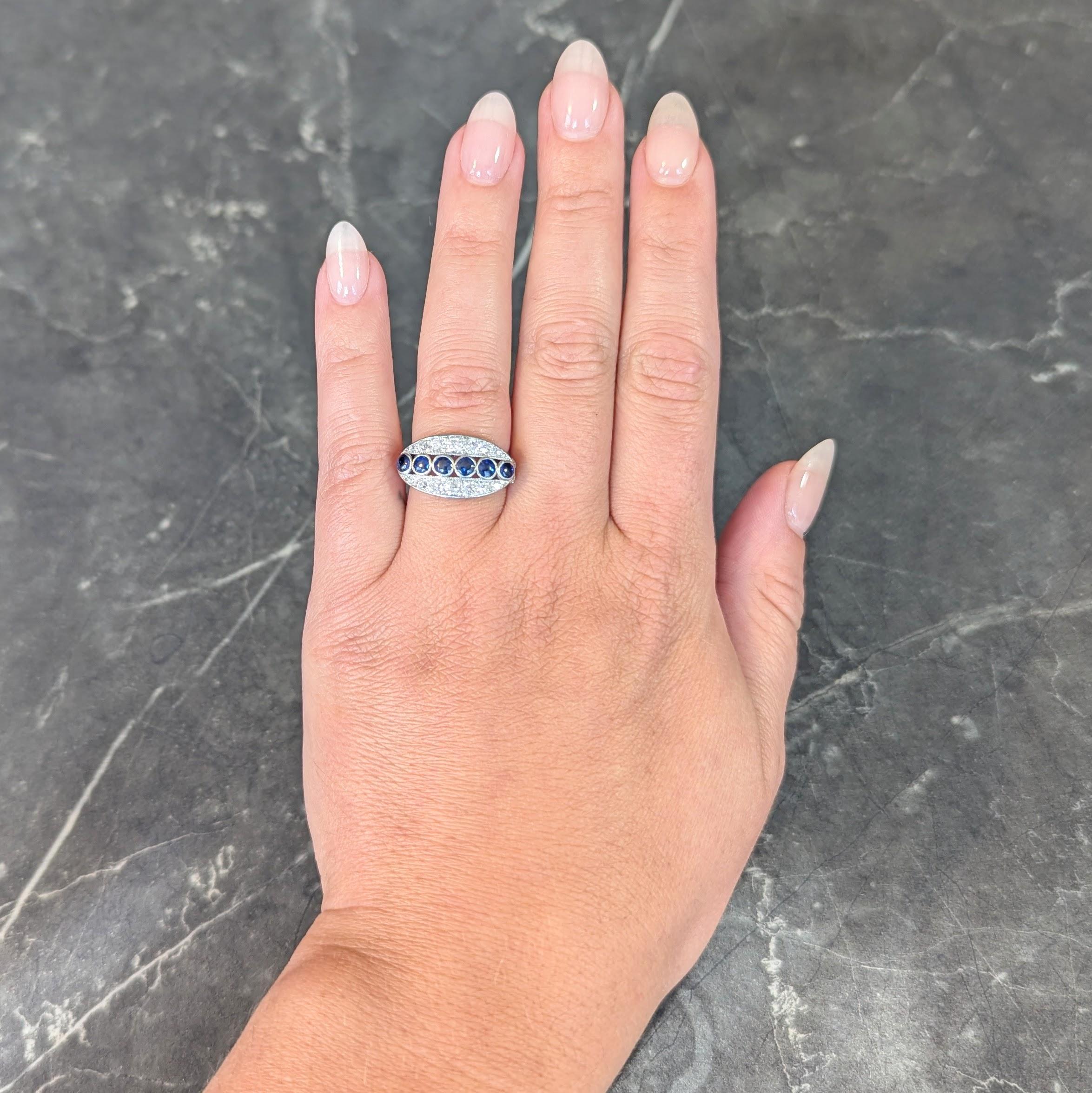Centré sur une rangée de saphirs ronds taillés et polis, sertis d'est en ouest en platine.
D'un poids total d'environ 1.05 carats - de couleur bleu moyen transparent 
Flanquée, du nord au sud, de rangées de diamants anciens de taille européenne