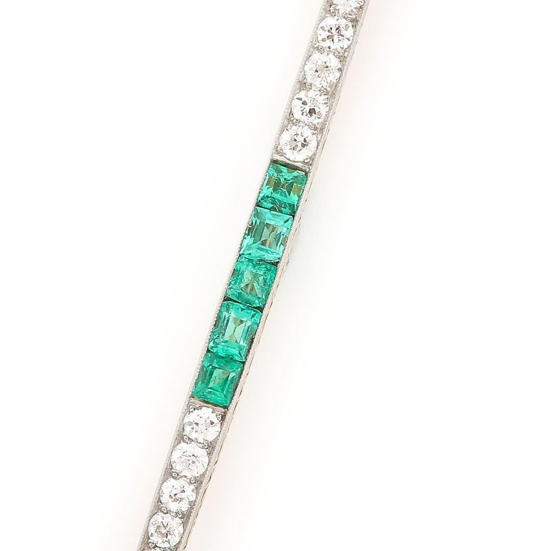 A superb quality 18ct gold emerald and diamond tapering bar brooch from the Art Deco era circa 1920. Measuring 60mm long the brooch comprises alternate sections of calibre cut emeralds and brilliant cut diamonds. The emeralds are very well matched
