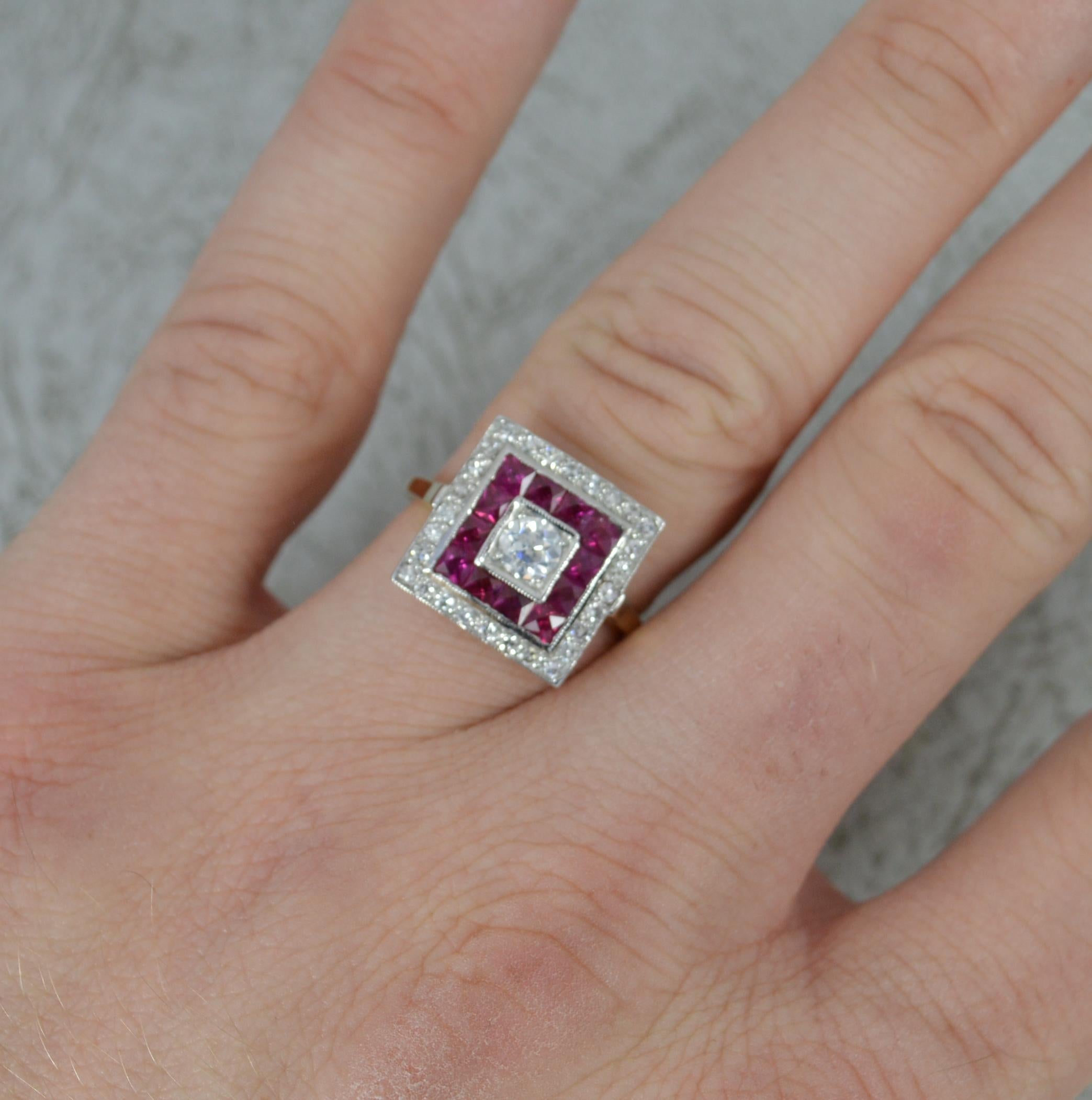 A superb square shaped target or halo cluster ring.
Solid 18 carat yellow gold shank with a platinum head setting.
Designed with an old European cut diamond to the centre, 0.25cts, full border of French cut rubies surrounding and a final border of