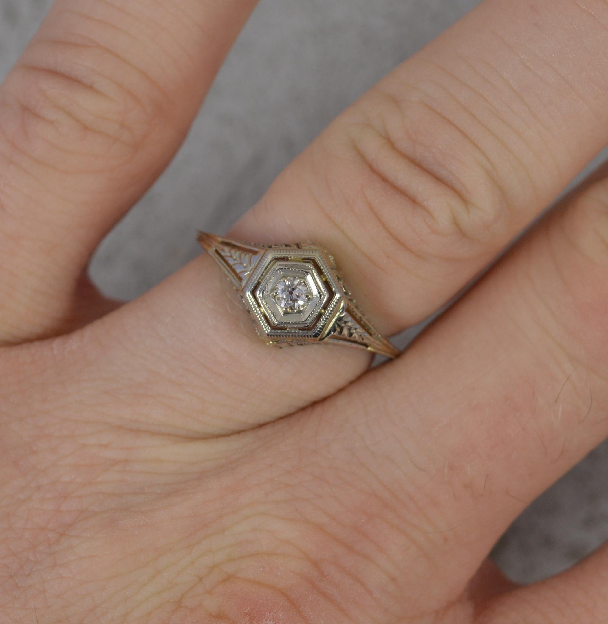 An antique diamond ring circa 1920.
Solid 18 carat white gold example throughout.
Set with a single, natural, old European cut diamond into a hexagonal head with pierced filigree finish.
9.3mm wide band to front.

CONDITION ; Very good. Crisp claws.