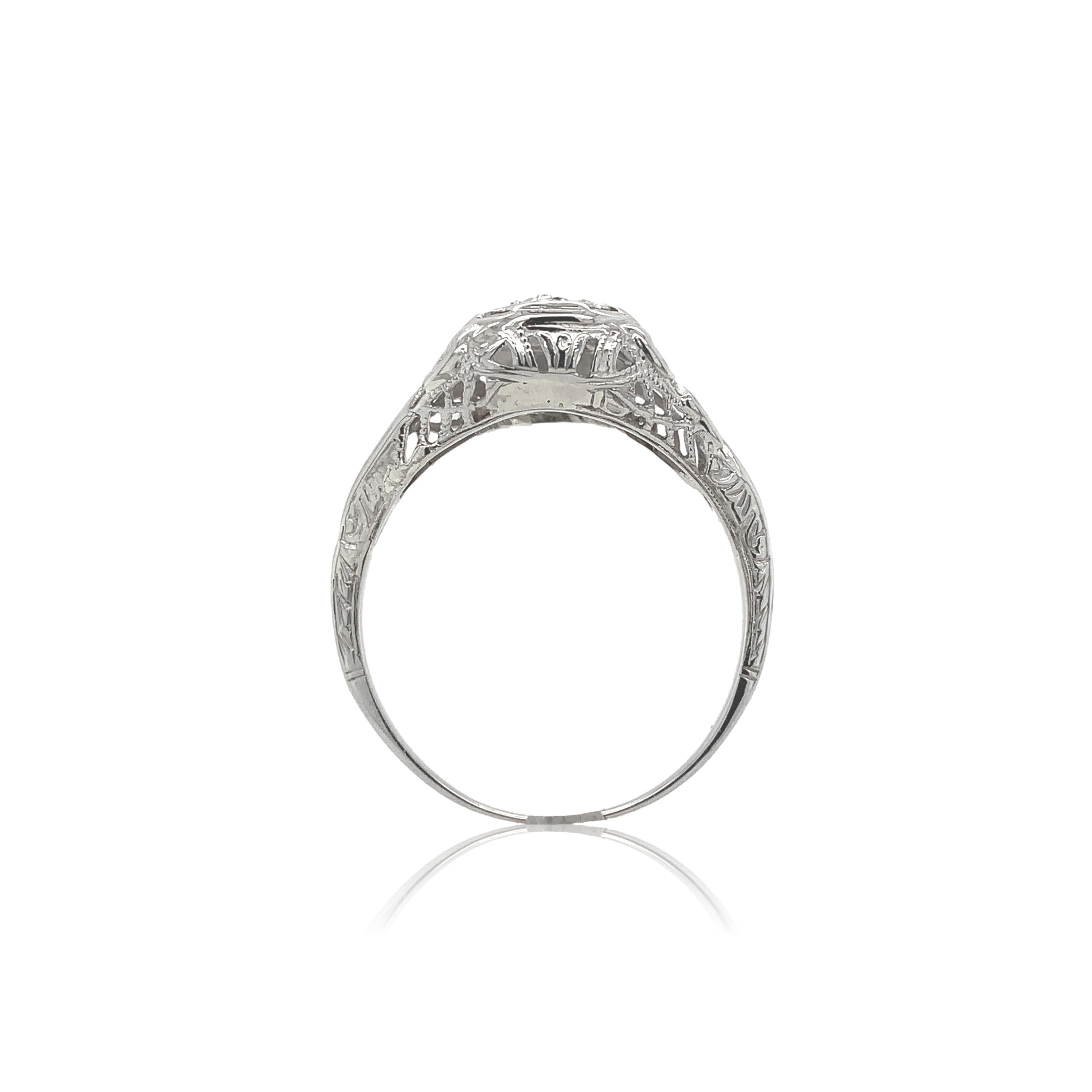 14K white gold filigree .14ct diamond ring. The European cut diamond weighs .14cts and has I1 clarity and H-I color and measures about 3mm. The diamonds are set with 4 new prongs. The filigree has ribbons or bows on each side. It looks like at some