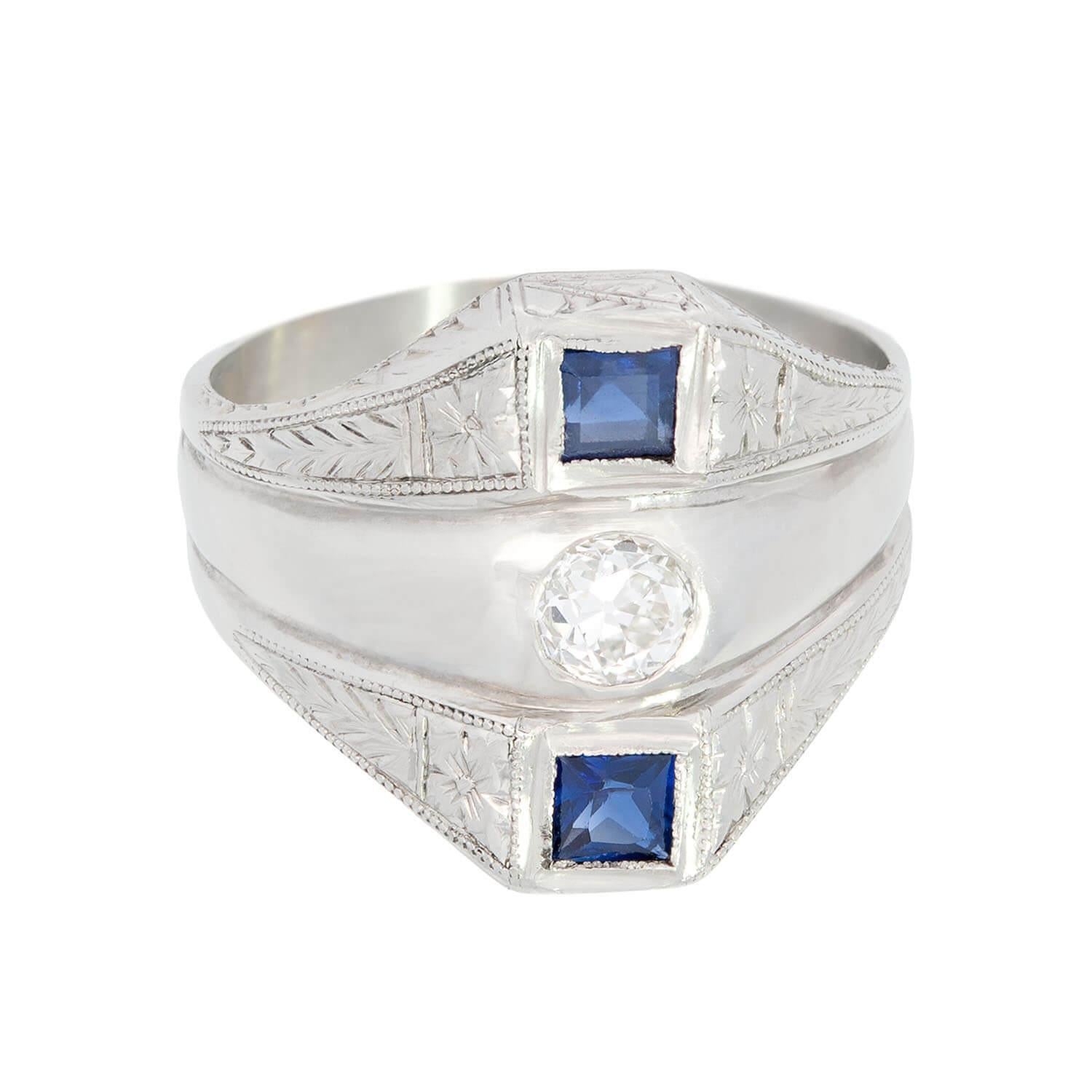 A magnificent diamond and synthetic sapphire ring from the Art Deco (ca1930) era! Crafted in 18k white gold, this ring features three bands, which are fused together to compose one, large piece. The top and bottom bands of the ring are identical and