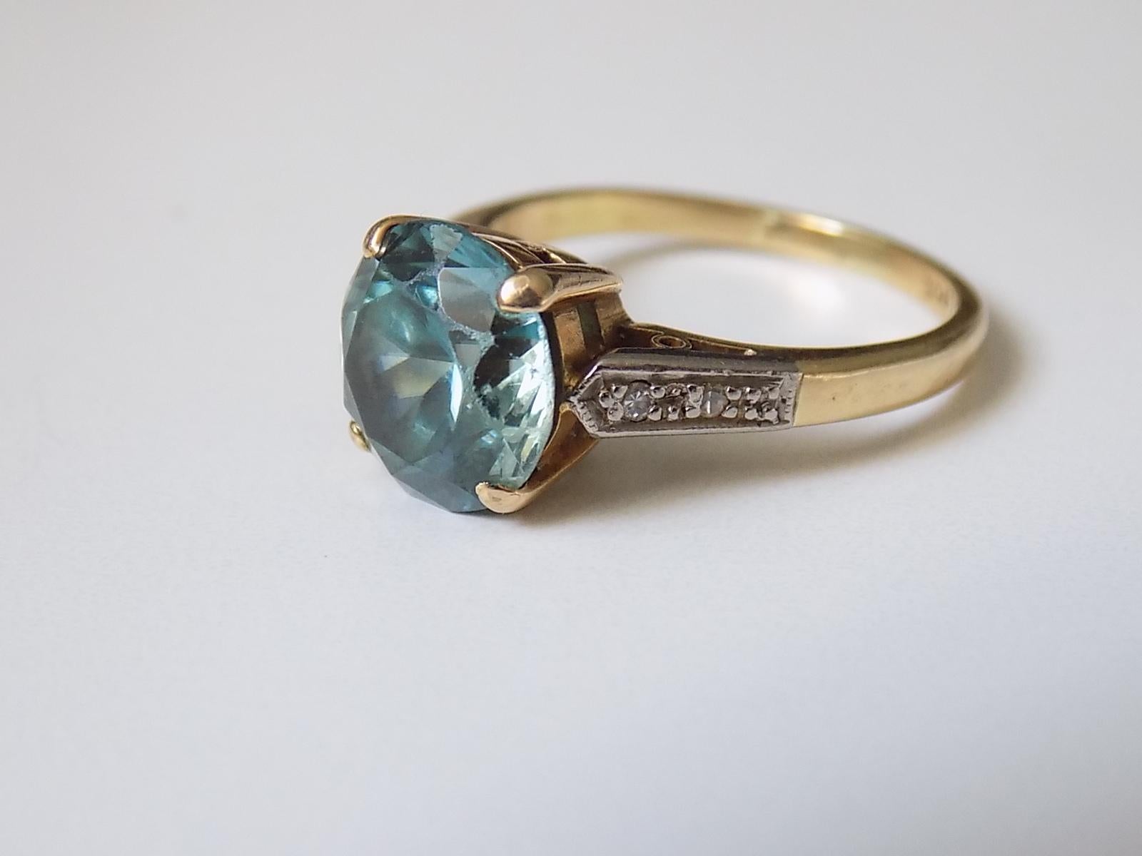 A Stunning Art Deco approx 4 Carat Blue zircon ring in 18 Carat yellow and white gold and on Diamond shoulders. English origin.
Size K UK, 5.5 US.
Height of the face 9mm.
Weight 4.6gr.
Marked 18CT for 18 Carat Gold