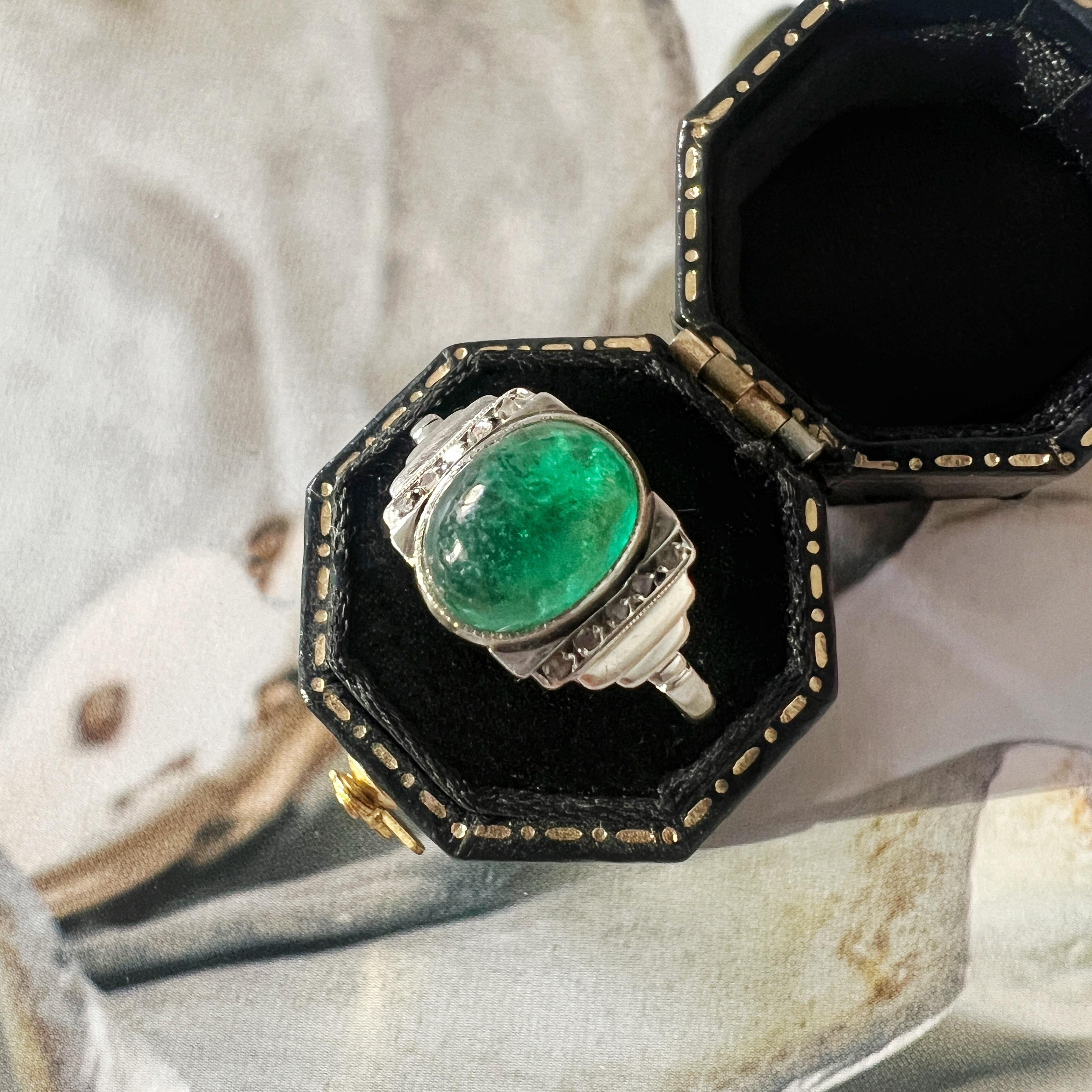 For sale a chic French work, 18K gold art deco ring. At the heart is a luscious emerald cabochon, exhibiting a mesmerizing and vivid green hue. The emerald, with its round dome shape, takes center stage, showcasing the allure of its natural