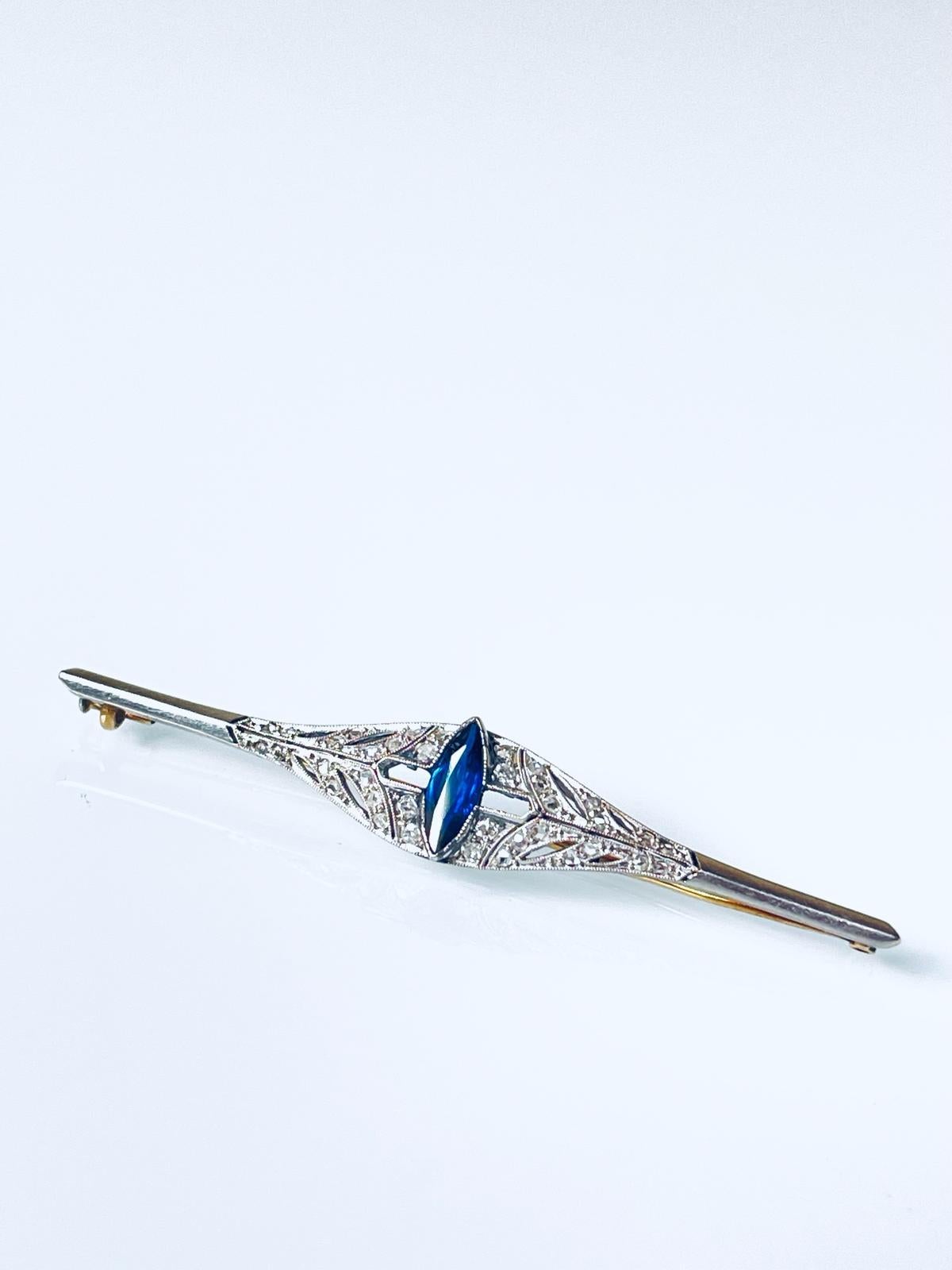 A stylish Art Deco brooch pin in platinum topped 18K yellow gold set with diamonds and marquise cut natural medium blue sapphire. The brooch comes with the box shown in the photo.

Item specifications: platinum-topped 18K yellow gold tested; 28 rose