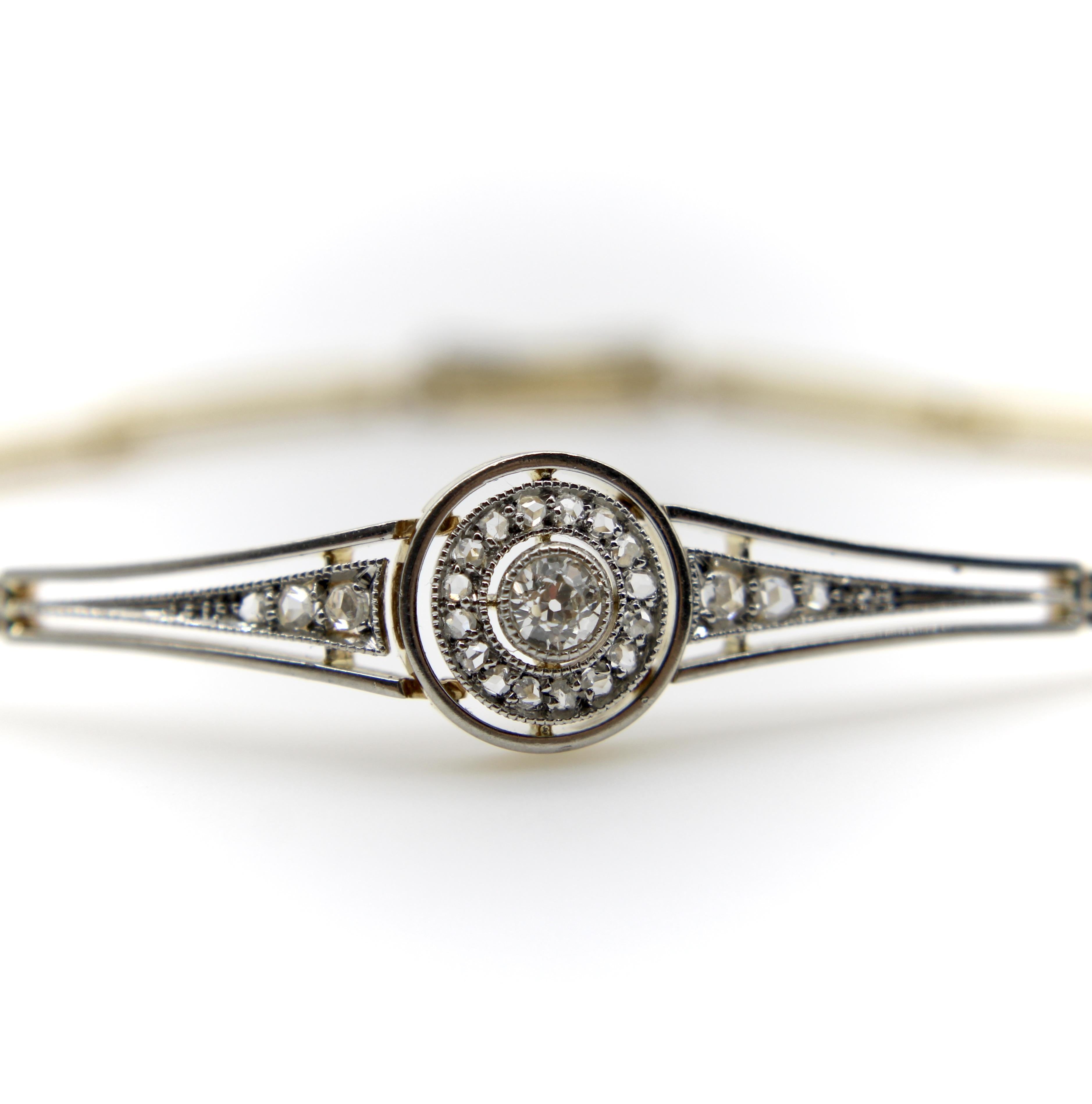 This gorgeous Art Deco bracelet centers around an Old European Cut diamond set into a bull’s eye element. The 3.75 mm diamond is bezel set, surrounded by a layer of Rose Cut diamonds and milgrain work, bordered by a final platinum outline. Off to
