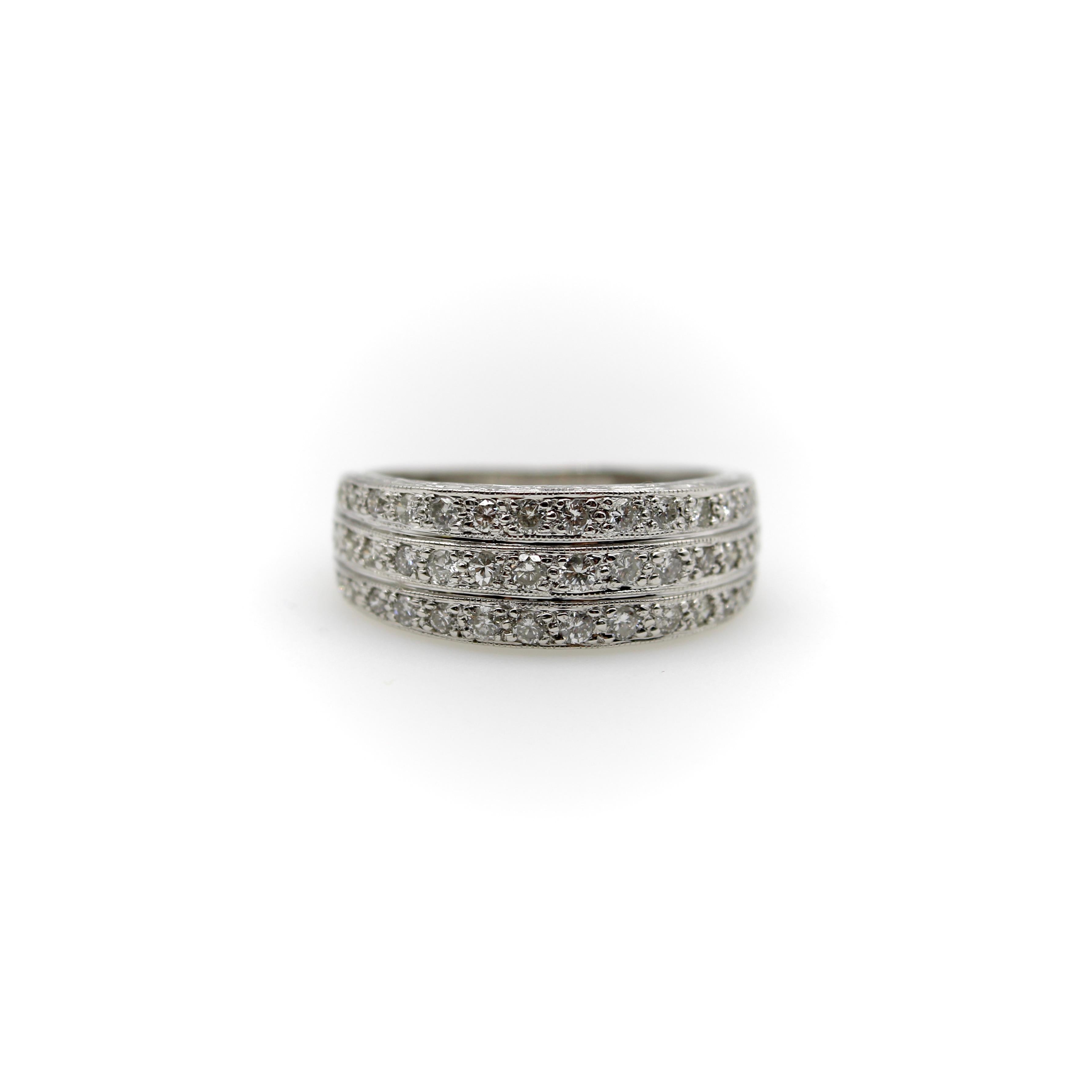 Questo anello Art Deco in oro bianco 18 carati ha tre file di diamanti che formano un fronte scintillante. I filari si presentano come tre bande che si uniscono alla base dell'anello per formare un'unica fascia solida. Ciascuna fila è delineata in