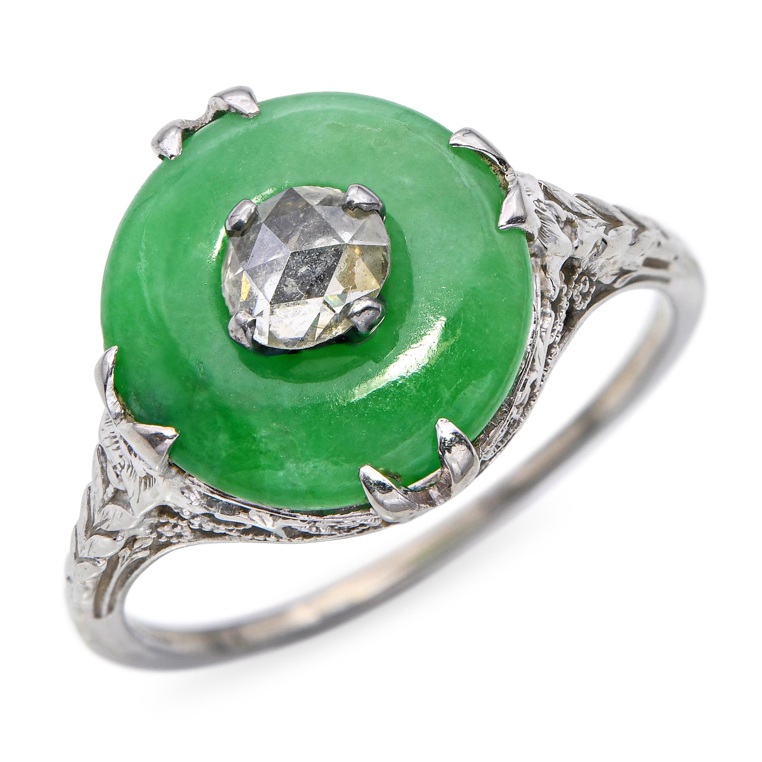 Este anillo, un llamativo y evocador tesoro Art Decó, centra un vívido disco de jade natural, cuyo tono verde saturado resplandece con la suave translucidez tan admirada en el jade antiguo. En su centro descansa un diamante talla rosa antiguo,