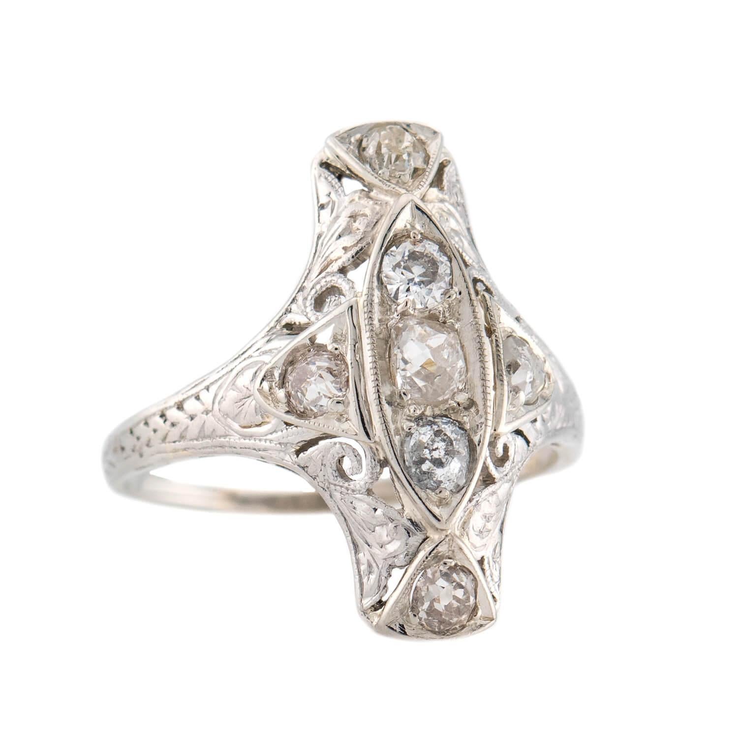 ¡Un anillo navette absolutamente exquisito de la época Art Déco (hacia 1920)! Elaborado en oro blanco de 18 quilates y platino, este anillo presenta una importante pieza central de estilo navette. El centro de la pieza central presenta 3 diamantes