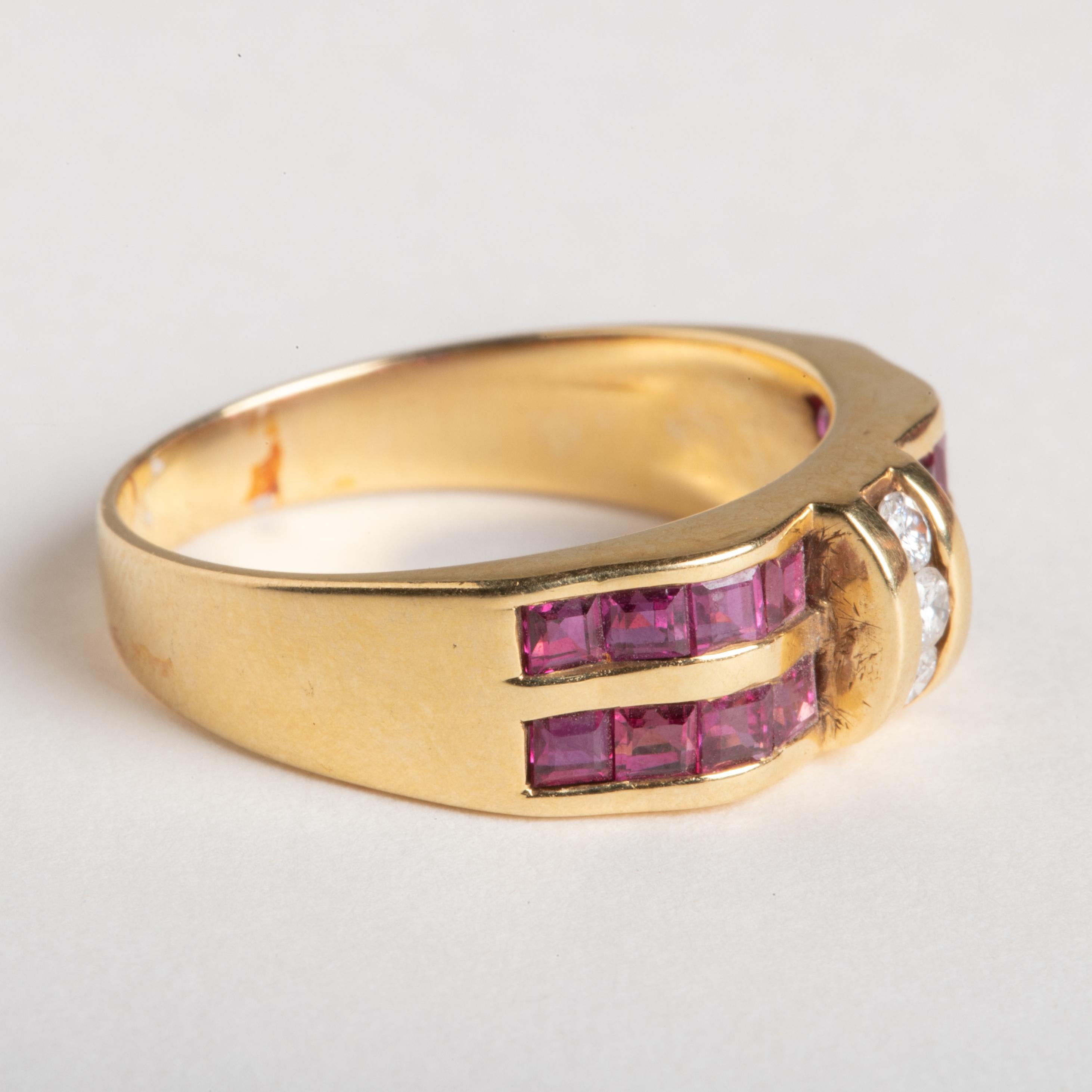 A stunning Art Deco 18k gold ring with two rows of square-cut, channel set rubies, and 3 round brilliant cut diamonds in the center.  The setting has a curved, dimensional shape that the rubies wrap within.  It's more like a band and could make an