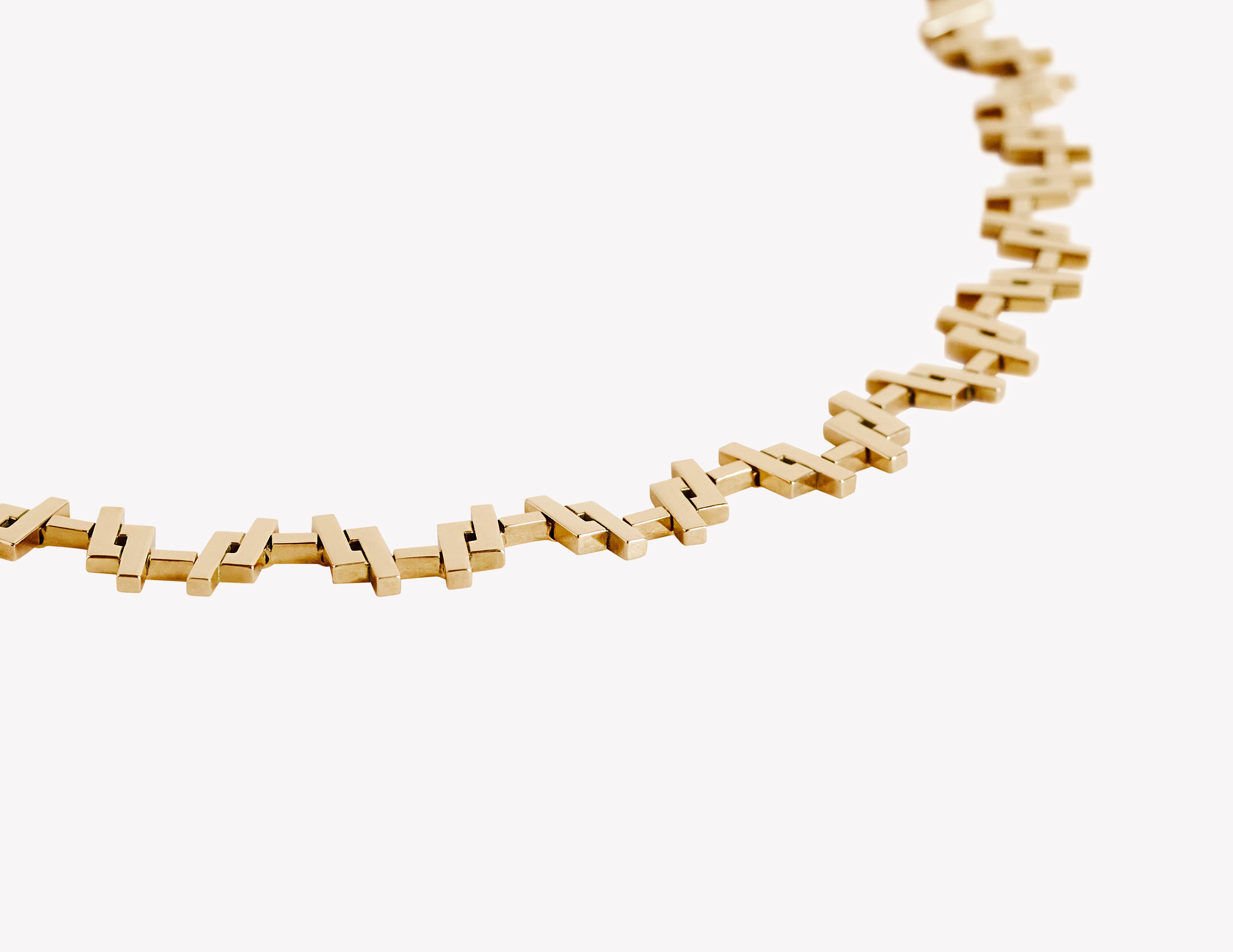 Le collier André : Expression audacieuse de l'élégance Art déco, le collier André est une étude de la géométrie, du rythme et de l'artisanat raffiné. Conçus en or jaune massif 18 carats, ses maillons allongés en forme d'allumettes créent un flux