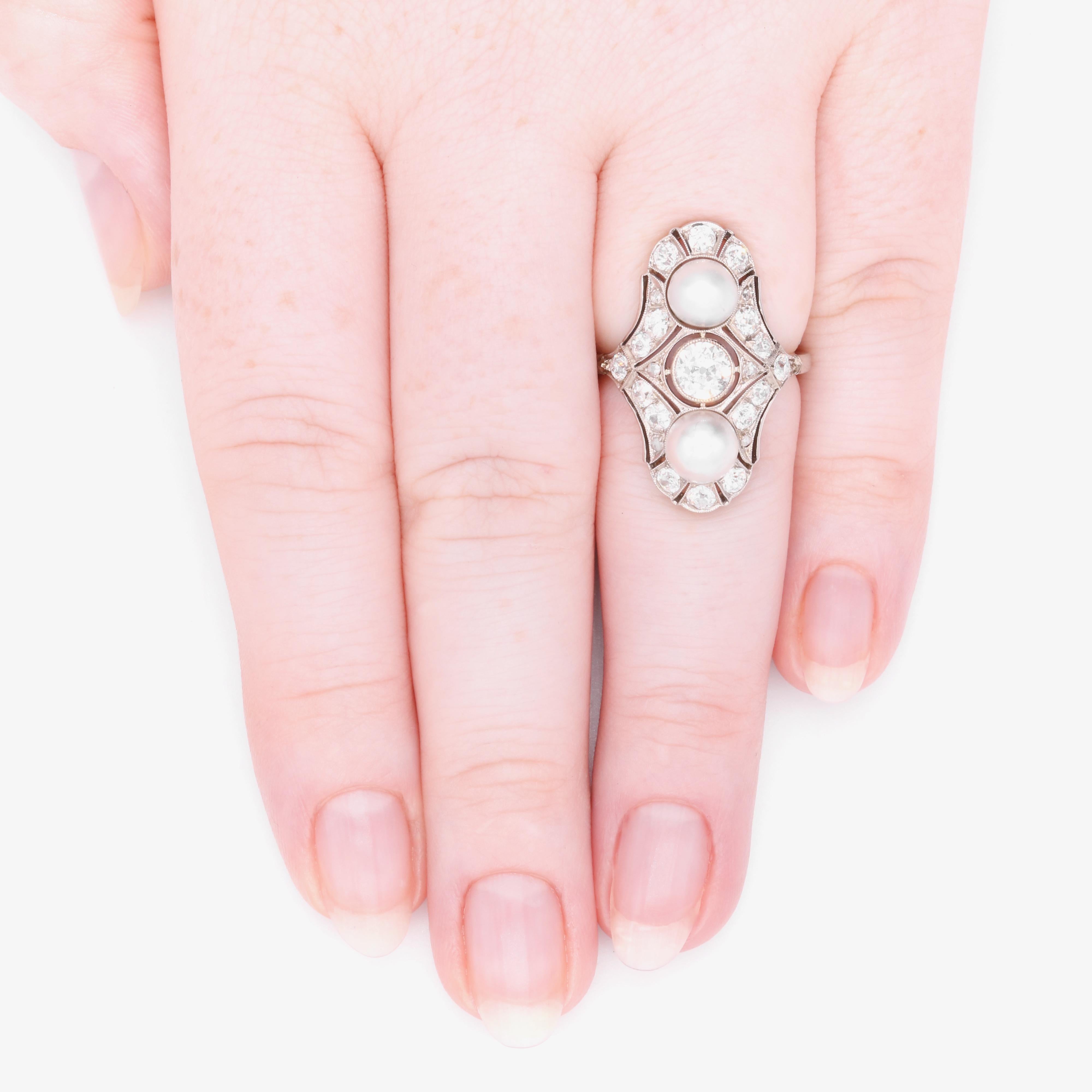 Ein Art-Deco-Ring aus Diamanten, Perlen und Weißgold, bestehend aus einem großen Diamanten mit altem europäischem Schliff, sechzehn kleineren Diamanten mit altem europäischem Schliff und sechs Diamanten mit Rosenschliff, gefasst in 18 Karat