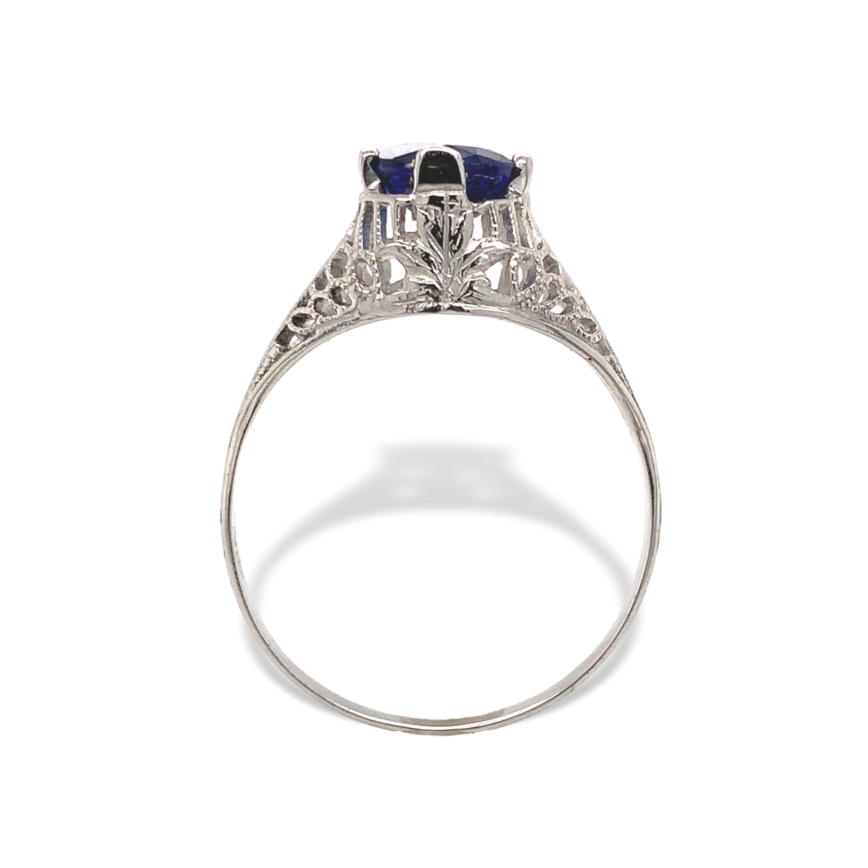 18K white gold Art Deco blue sapphire filigree ring. The ring features a genuine earth mined oval cut blue sapphire. It measures about 6mm x 4.5mm and weighs .87 cts. The sapphire is a royal blue color. The ring fits a size 7 finger, weighs 1.07dwt.