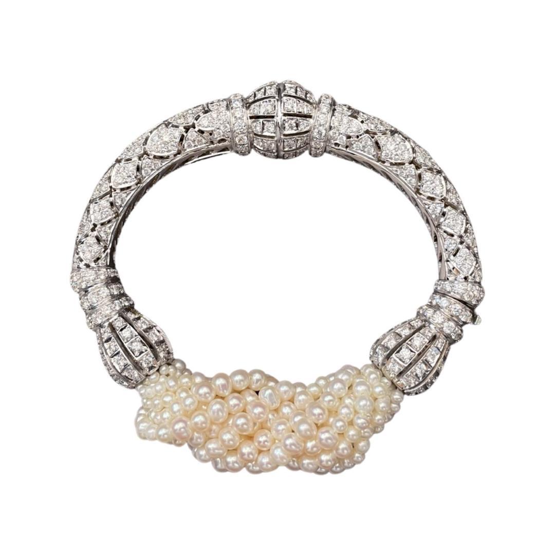 The complexity of the design in this 18k white gold Art Deco inspired bracelet covered in 12.46 carat diamonds, reflects the modern and sleek spirit of the era. The Fresh Water Pearls twisted strings uplift the composition of such an intricate