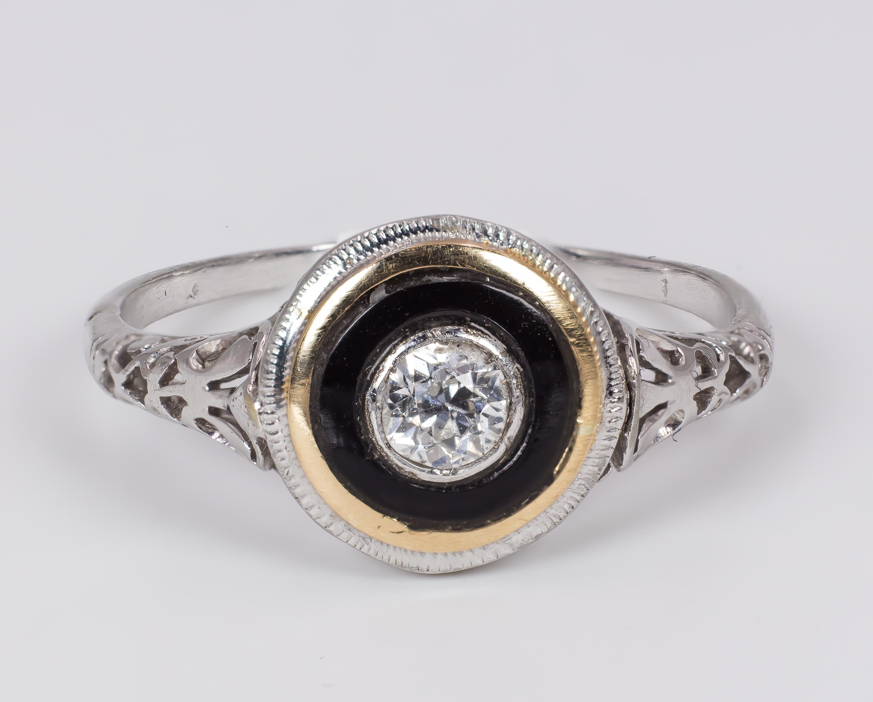This cool Art Deco gold, diamond and onyx solitaire ring dates from the 1930s.
It is crafted in 18K white gold throughout, and is decorated with a central 0,20ct old European cut diamond, surruounded by an internal circular onyx band and by an