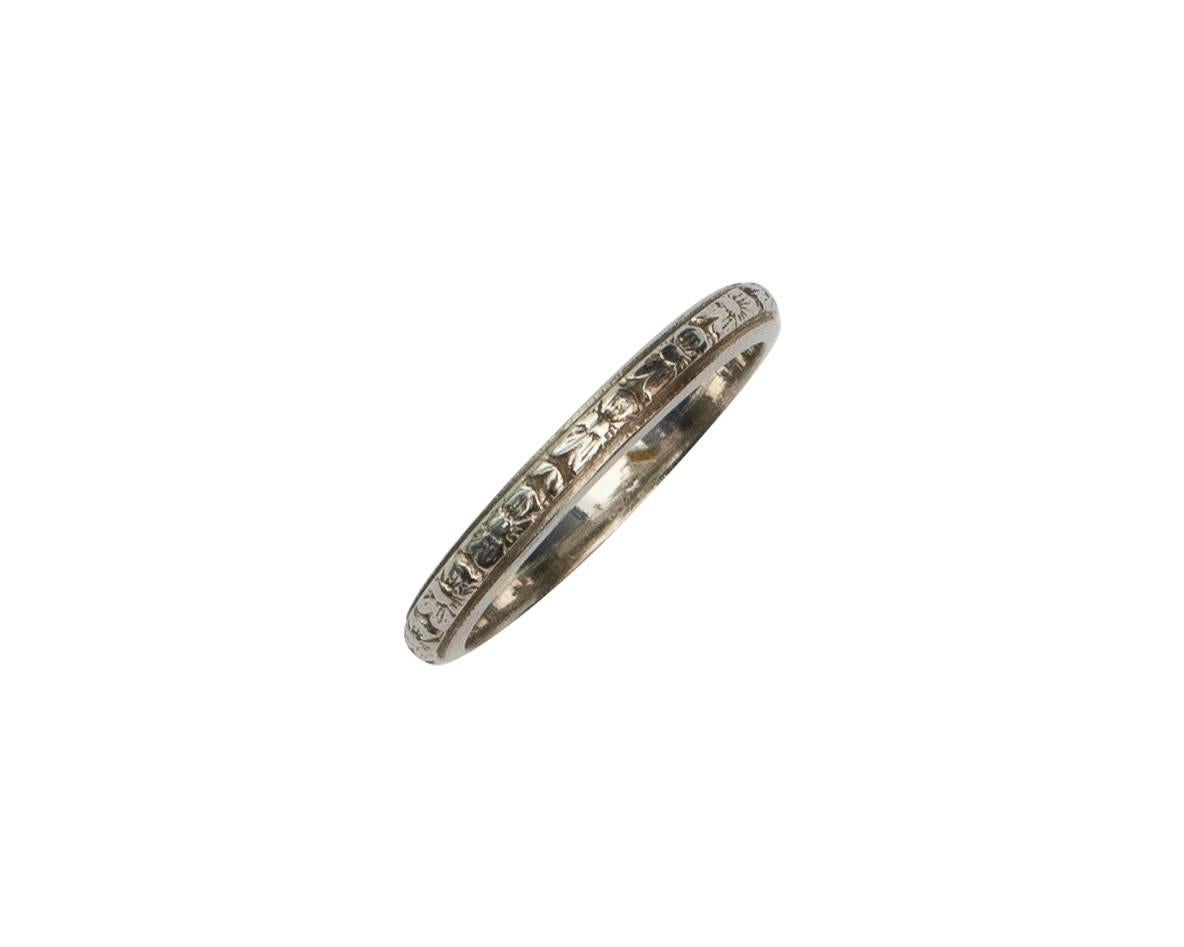 This band is a beautiful representation of the  1920's Art Deco era. With a detailed floral carved design in the white gold band, making it the perfect ring to say 