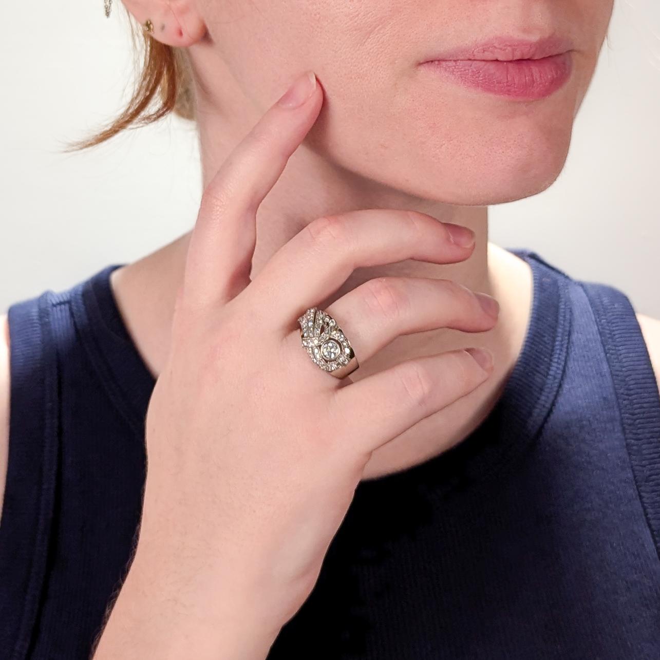 A fine white gold & diamond ring.

In 18 karat white gold.

With a central transitional round brilliant cut diamond (0.25± Ct) accompanied by 37 single cut diamonds.

The wide tapered white gold band has a slight gold tone.

Marked to the