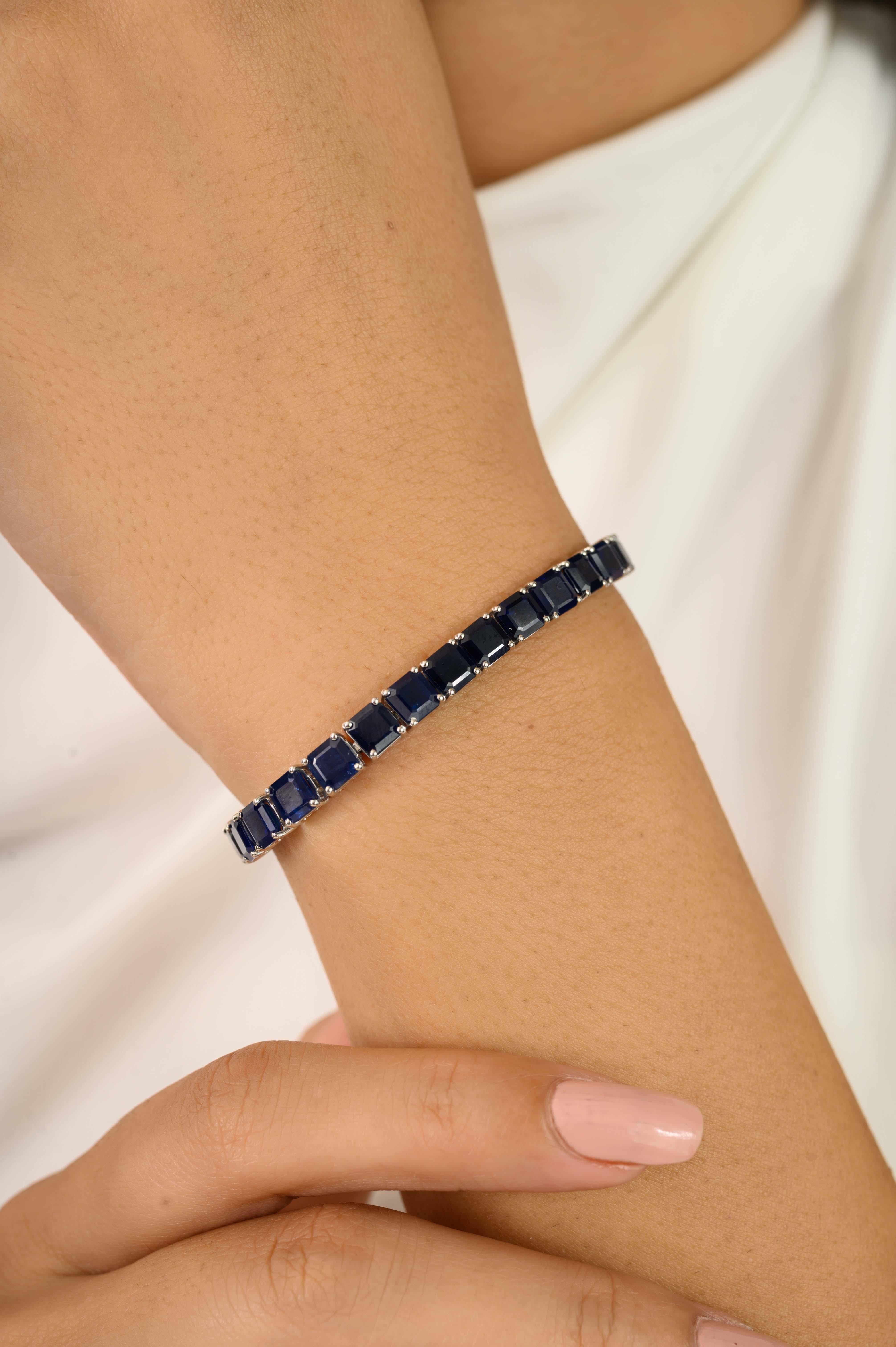 Cet exquis bracelet de tennis en saphir Art déco est réalisé en or blanc 18 carats et met en valeur 20,32 carats de saphirs bleus naturels de taille carrée. Chaque saphir est solidement serti à quatre pointes en ligne continue, créant ainsi un