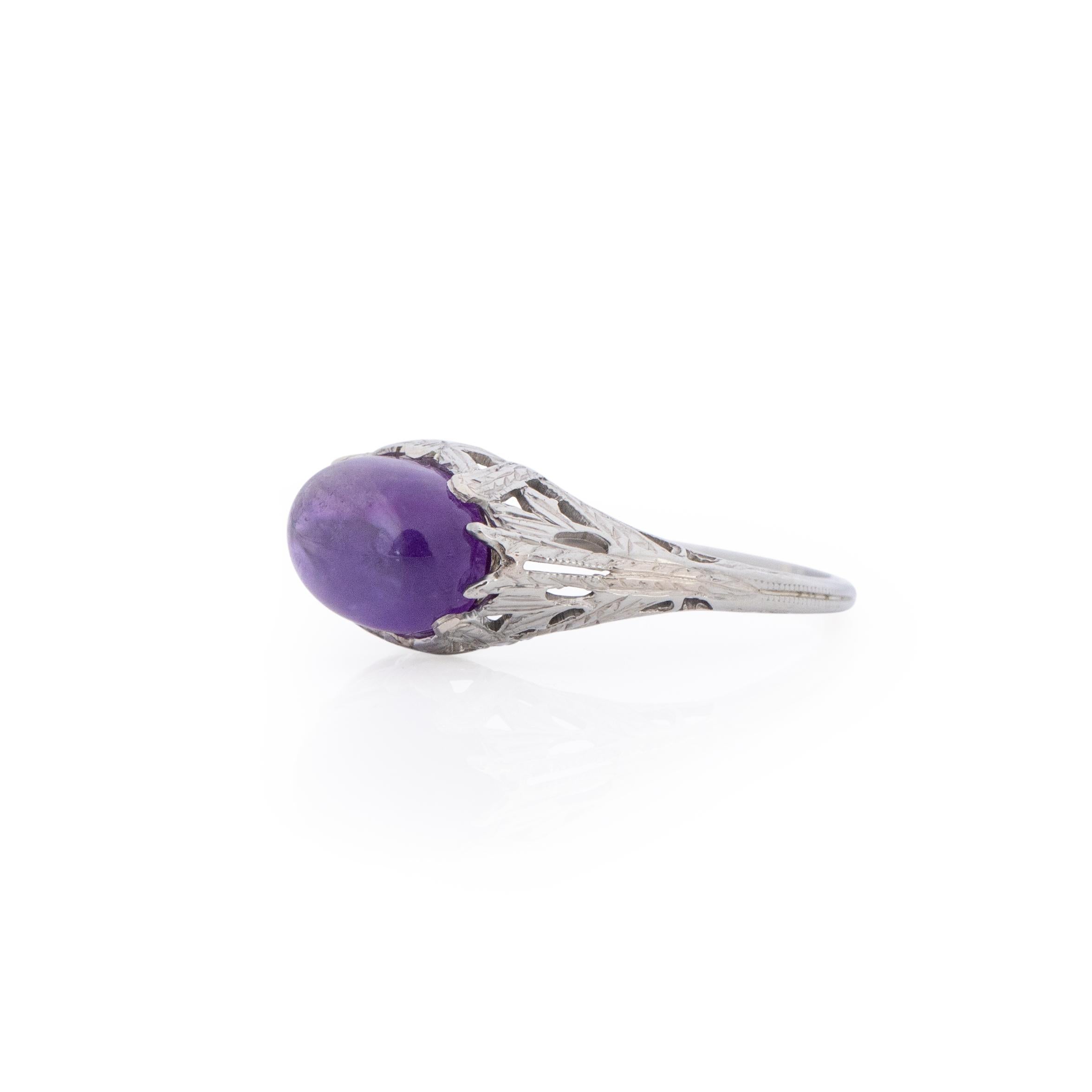This unique beauty, is a amethyst lovers dream. The vibrant purple amethyst cabochon sits in a breathtaking 18k white gold filigree mount. the filigree design wraps around the amethyst giving it a unique look that makes this art deco ring one of a