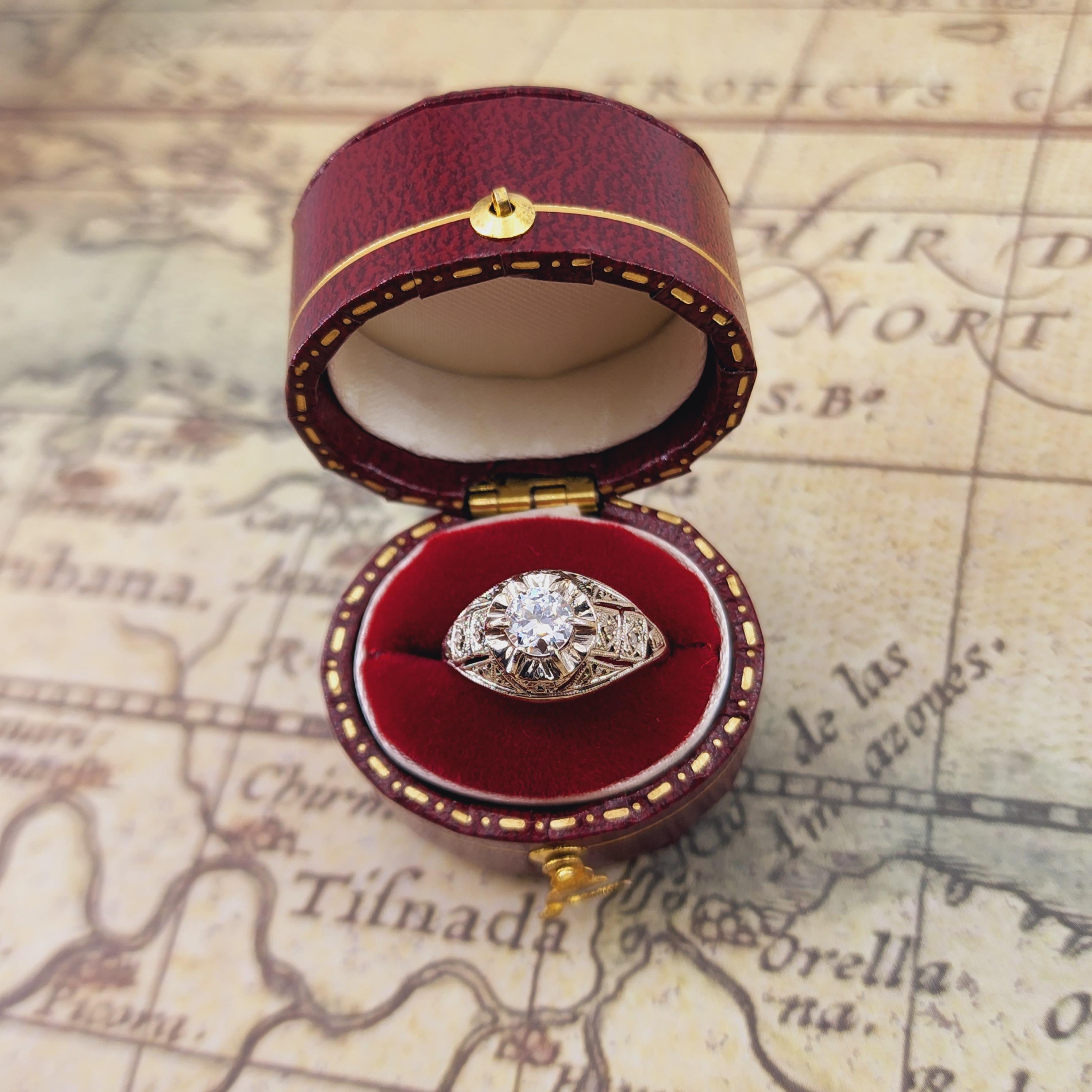 Discover the timeless elegance of this exquisite Art Deco-era ring from the 1910s, meticulously crafted in luxurious 18kt white gold. At its center lies a stunning Full Cut Diamond, approximately 0.45 carats, showcasing a beautiful G-H color and SI1