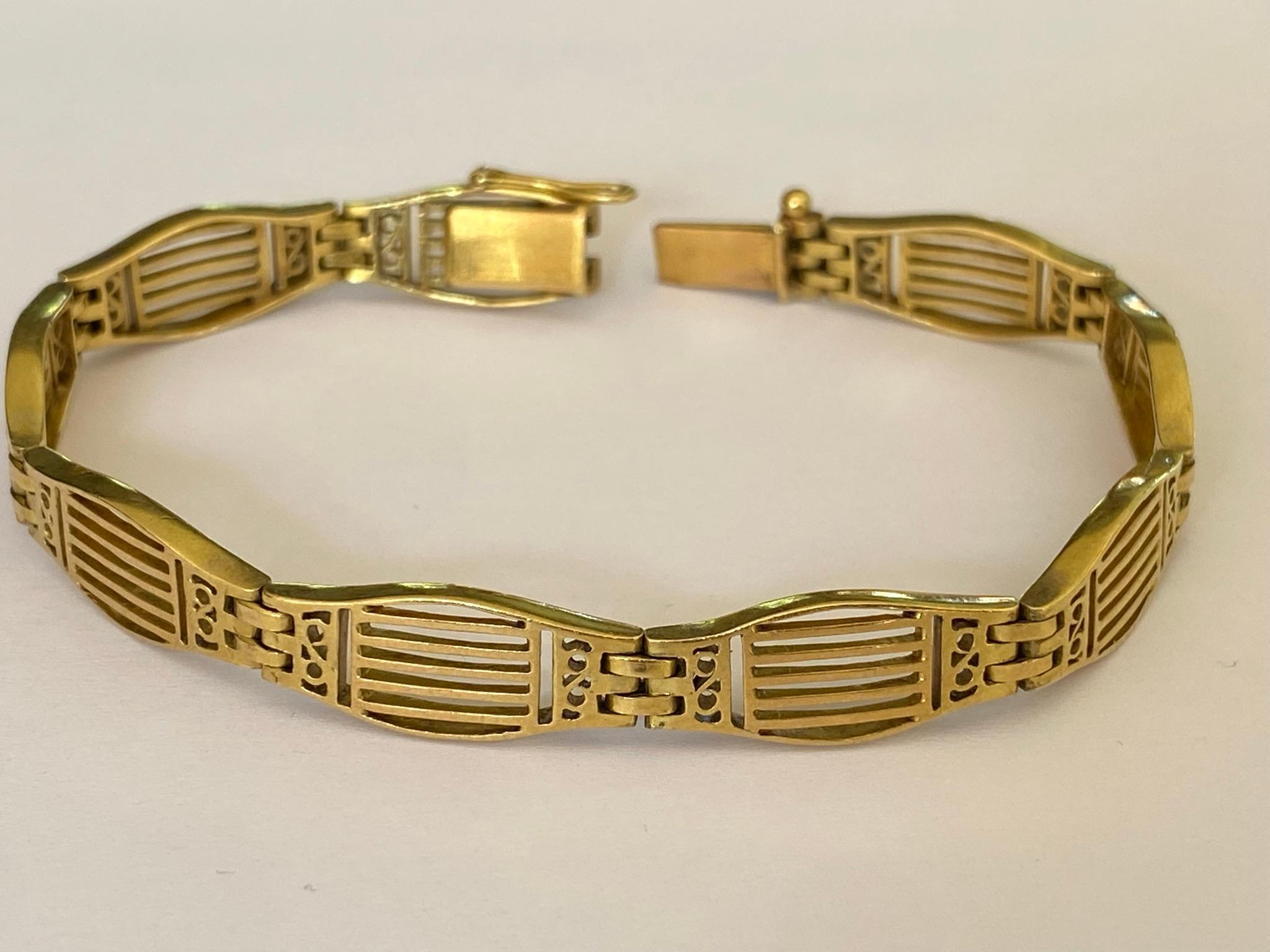 Crafted in the 1920s from 18kt yellow gold, this Art Deco French link bracelet features delicate linear piercing. The bracelet measures 7 inches long and weighs 20.42 grams. 
