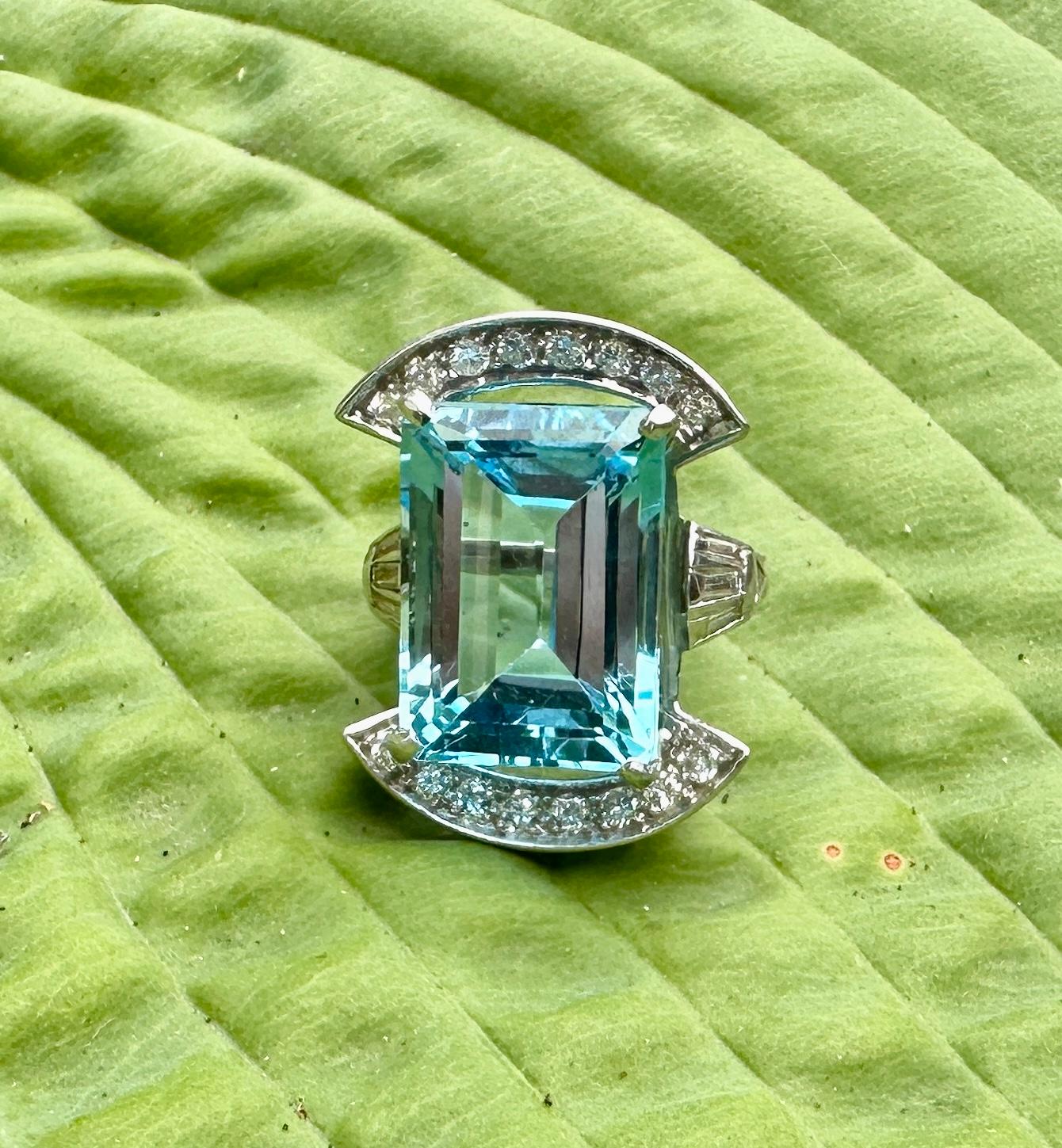 THIS IS A MAGNIFICENT ANTIQUE ART DECO 19 CARAT EMERALD CUT FINE BLUE TOPAZ RING WITH 24 GORGEOUS ROUND, EMERALD AND FANCY TRIANGLE CUT DIAMONDS SET IN A STUNNING DESIGN IN PLATINUM.  
THE MAGNIFICENT MONUMENTAL 19 CARAT BLUE TOPAZ IS 18MM LONG AND