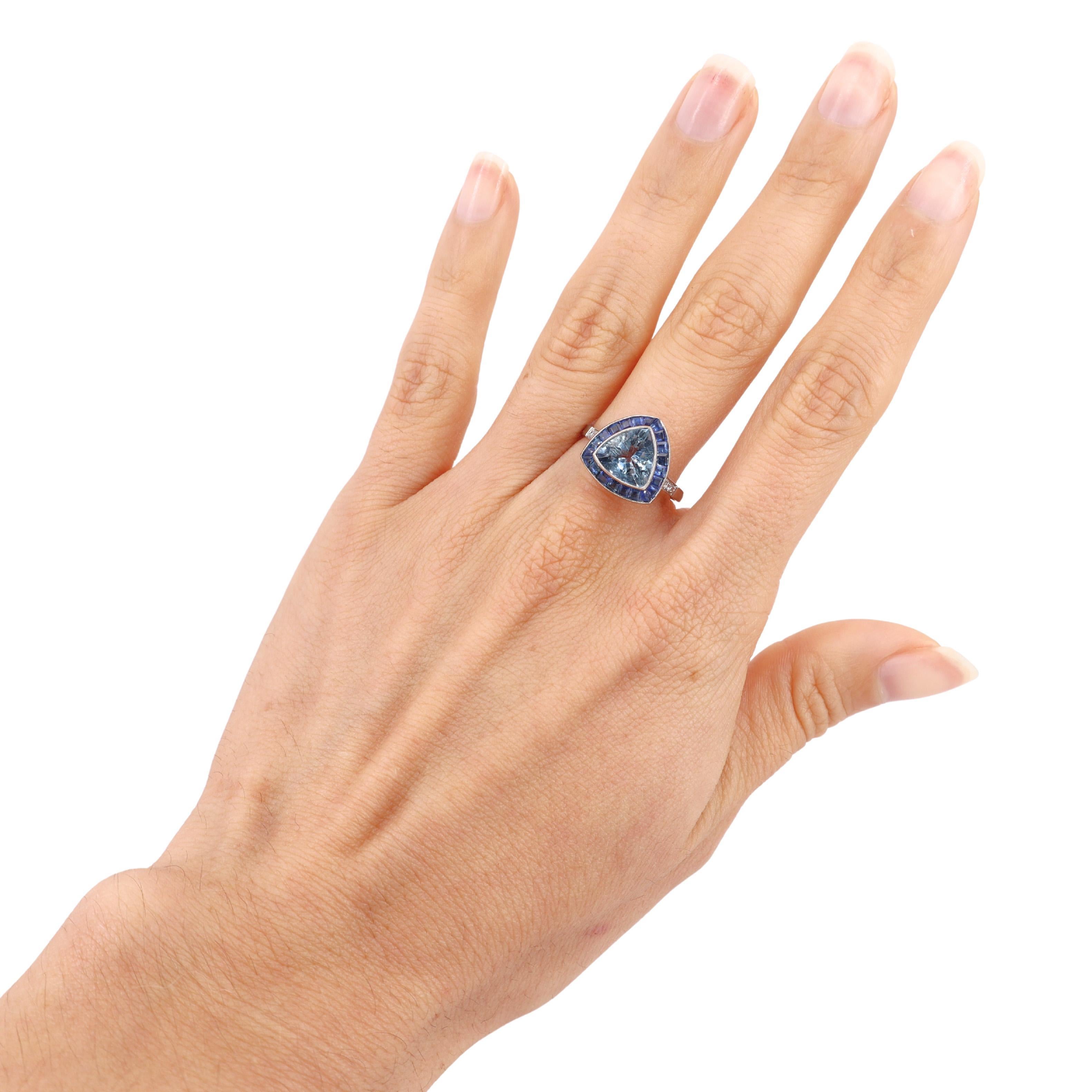 Introducing a stunning Platinum Cocktail Ring that embodies elegance and sophistication. At its heart is a trillion-cut aquamarine weighing 1.48 carats, radiating a breathtaking blue that captivates the eye.

Surrounding the aquamarine are 21