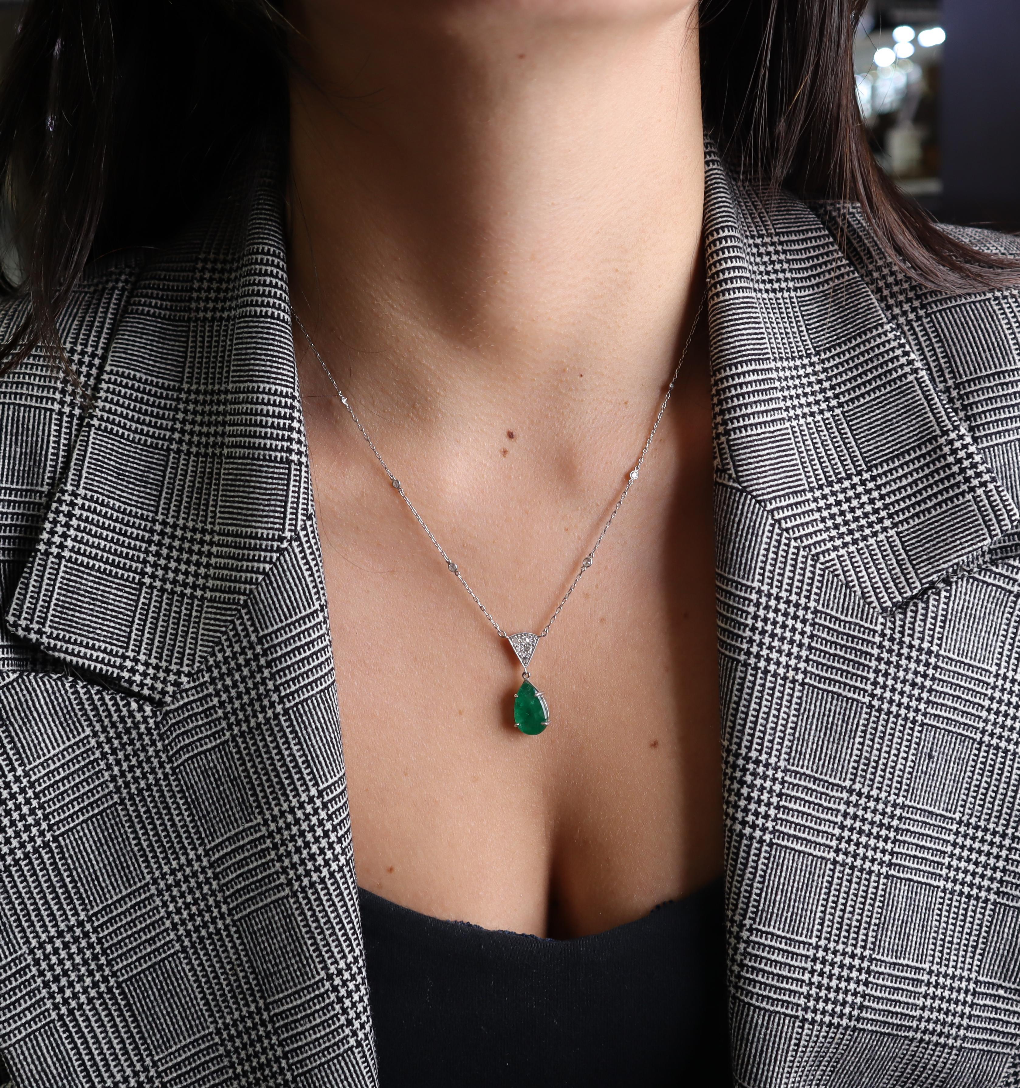 Este exquisito collar Art Déco de platino, de hacia 1920, representa una obra maestra de elegancia atemporal y artesanía excepcional del apogeo de la Era del Jazz. En su cautivador centro yace una impresionante esmeralda natural en forma de pera de